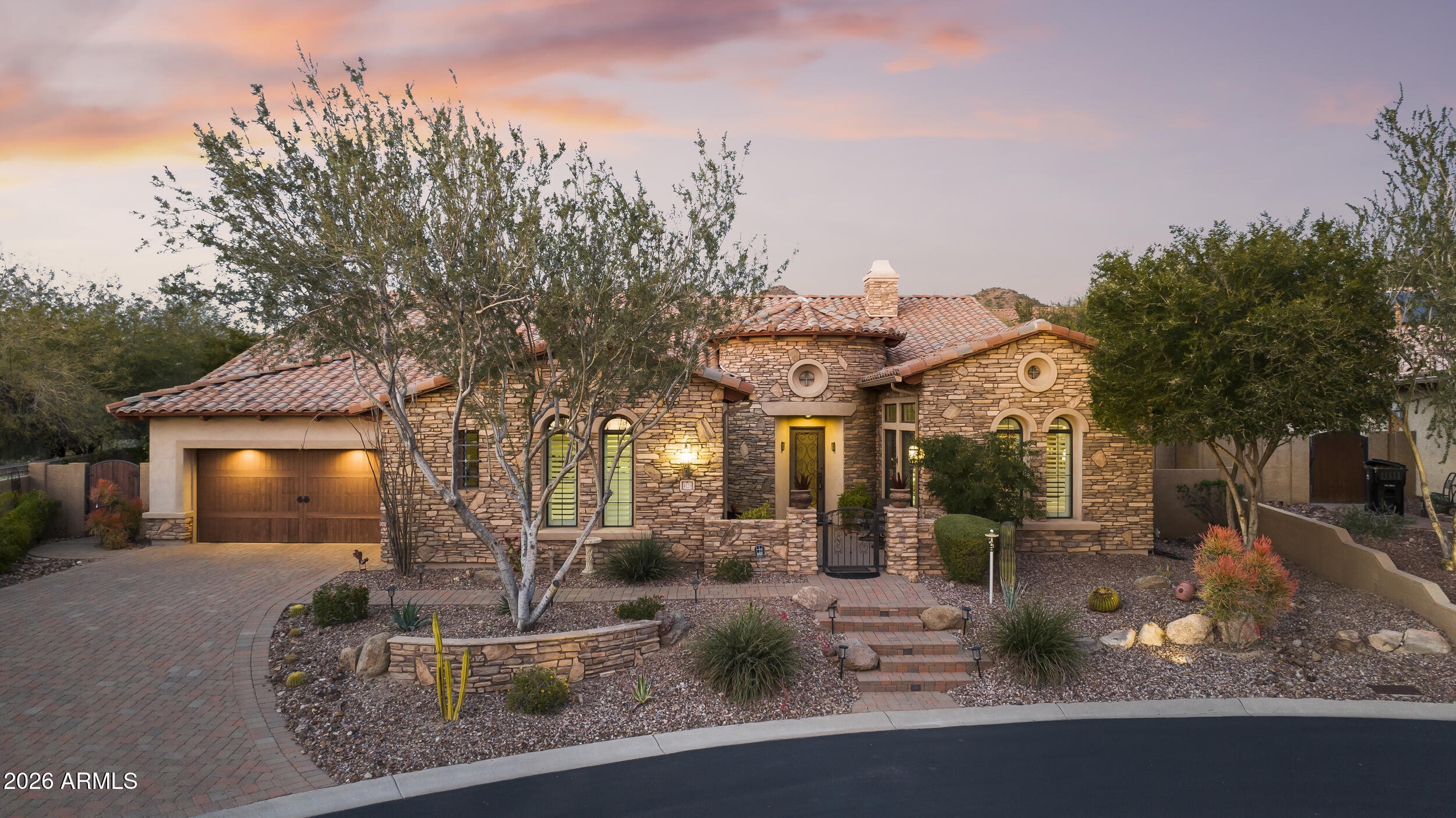 Tucked away at the quiet terminus of a serene cul-de-sac and located in the Las Sendes Community. This property features a brand-new roof underlayment installed this year, along with three HVAC units that have been recently upgraded over the past few years for enhanced comfort and efficiency. This exquisite estate serves as a private sanctuary, greeting you with the refined elegance of a custom paver driveway, classic stucco finish, and an atmosphere of total seclusion. The residence is masterfully designed for both intimacy and grand-scale entertaining, boasting a sophisticated split floor plan where each of the four spacious bedrooms enjoys the luxury of its own private en-suite bath. Enjoy the private resort style pool, firepit, outdoor kitchen and spa with oversized grassy backyard. Inside, the home breathes with soaring ceilings and timeless architectural details, from the rich textures of eight-foot solid wood doors to the artistic precision of elegant, coffered ceilings in the formal dining room. Whether you are retreating to the dedicated executive office or indulging in the primary suite. A resort-caliber sanctuary featuring engineered wood floors, a private sitting area, and a spa-inspired bath with dual walk-in closets, every inch of the home exudes curated comfort. At its heart lies a gourmet chef's kitchen, anchored by a monolithic granite island and custom cabinetry, equipped with professional-grade tools including a six-burner gas cooktop, double ovens, and a walk-in pantry. This social hub, complete with a dedicated bar area and a charming, beamed breakfast nook, flows effortlessly into a lush outdoor oasis via patio doors protected by heavy-duty screens. An integrated surround sound system carries the ambiance from the interior to the covered, color-stamped patio, where a heated pool with a waterfall feature and a relaxing hot tub set the stage for alfresco evenings. Guests can gather around the gas firepit or the fully equipped outdoor kitchen featuring a built-in grill, sink, and fridge while enjoying the mature landscaping and fresh citrus from your own lemon trees. Enhanced by modern luxuries like whole-home water filtration, hot water on demand, and a three-car finished garage with custom built-ins, this property offers a rare opportunity to inhabit a lifestyle of quiet opulence and effortless Arizona charm.