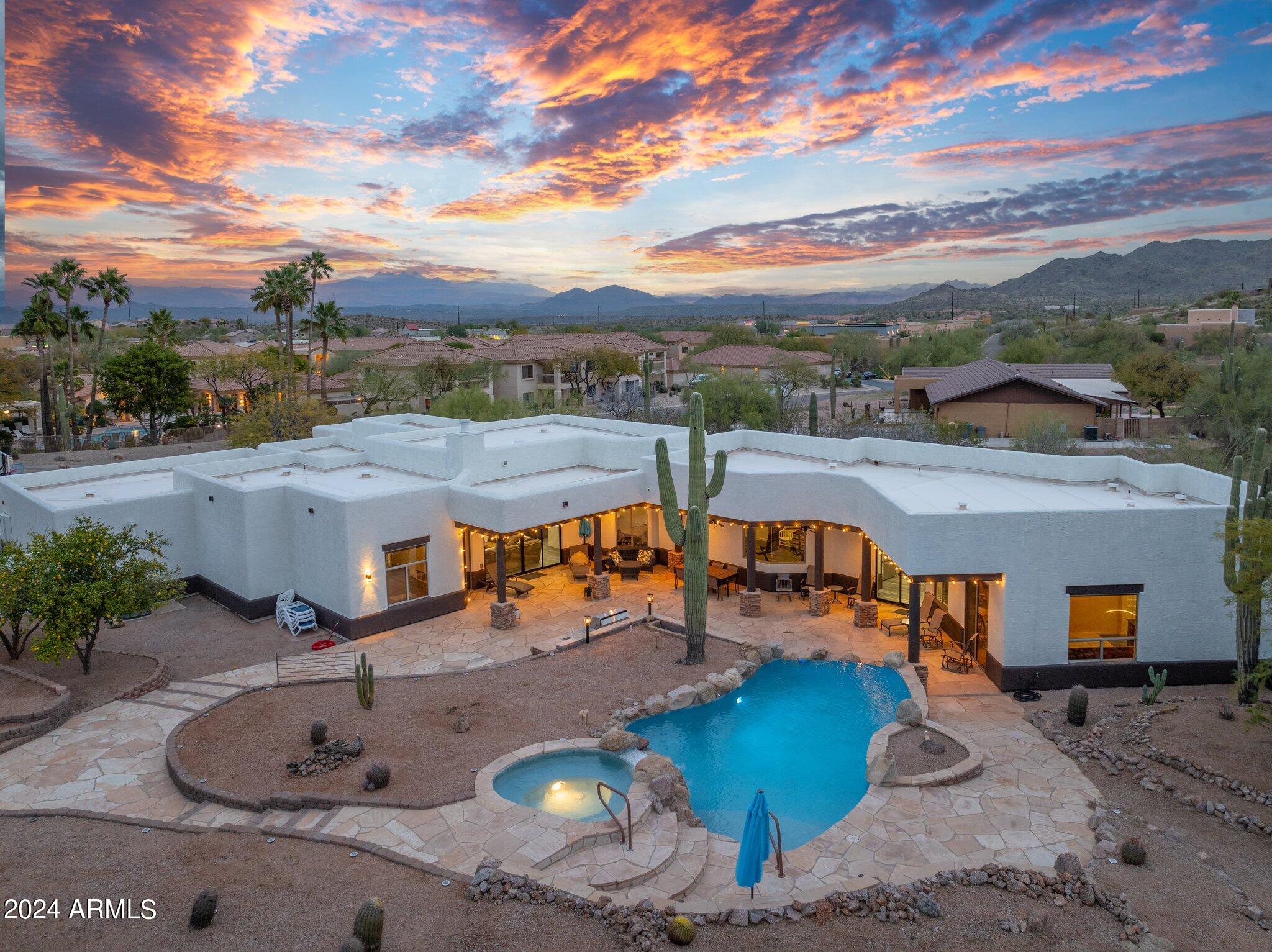 Fountain Hills living at its finest. Come home to this spacious 5 bedroom 4 bathroom contemporary gem nestled on a generous ¾ acre lot with natural desert surrounds and plenty of room/ privacy from the neighbors.  Pull into a 3 ½ car garage with ease, and enjoy having room for a private workshop, and/or storage for a boat, ATV, motorcycle or whatever toys you may have.  The pool, with a classic waterfall feature, hot tub, and built in BBQ are the perfect place to entertain guests or just simply spend a quiet evening with your significant other under the stars.  The large sliding glass doors are as pretty as a picture as they frame the backyard/ pool and let in beautiful natural light. This house aims to please with 3,800 sqft attention to detail.  Feel refreshed and calm with tall ceilings, large bedrooms an airy great room and an open concept kitchen.   The kitchen is crisp, clean and elegant featuring quartz countertops with a waterfall edge.   The large island and cooktop is set up for entertaining guests.  Double ovens and all stainless steal appliances make cooking and cleaning a breeze.  The ample master bedroom features a spacious walk-in closet, and a master bath that provides split vanities, separate soaking tubs and a large walk-in shower with dual shower heads - all fully updated in 2023. Private access to the pool and hot tub are conveniently located right off the master.  Another hidden gem of this house is a large fully functional mother- in - law suite.  The suite features private access, 1 ½ baths, complete kitchen with an island and double ovens, separate access to the pool/hot tub, an on-suite bathroom with double vanities, walk-in shower, and its own dedicated laundry room.  This suite is made with ease of use in mind and has the potential for some extra rental income. Make this house your home and enjoy all that is has to offer.