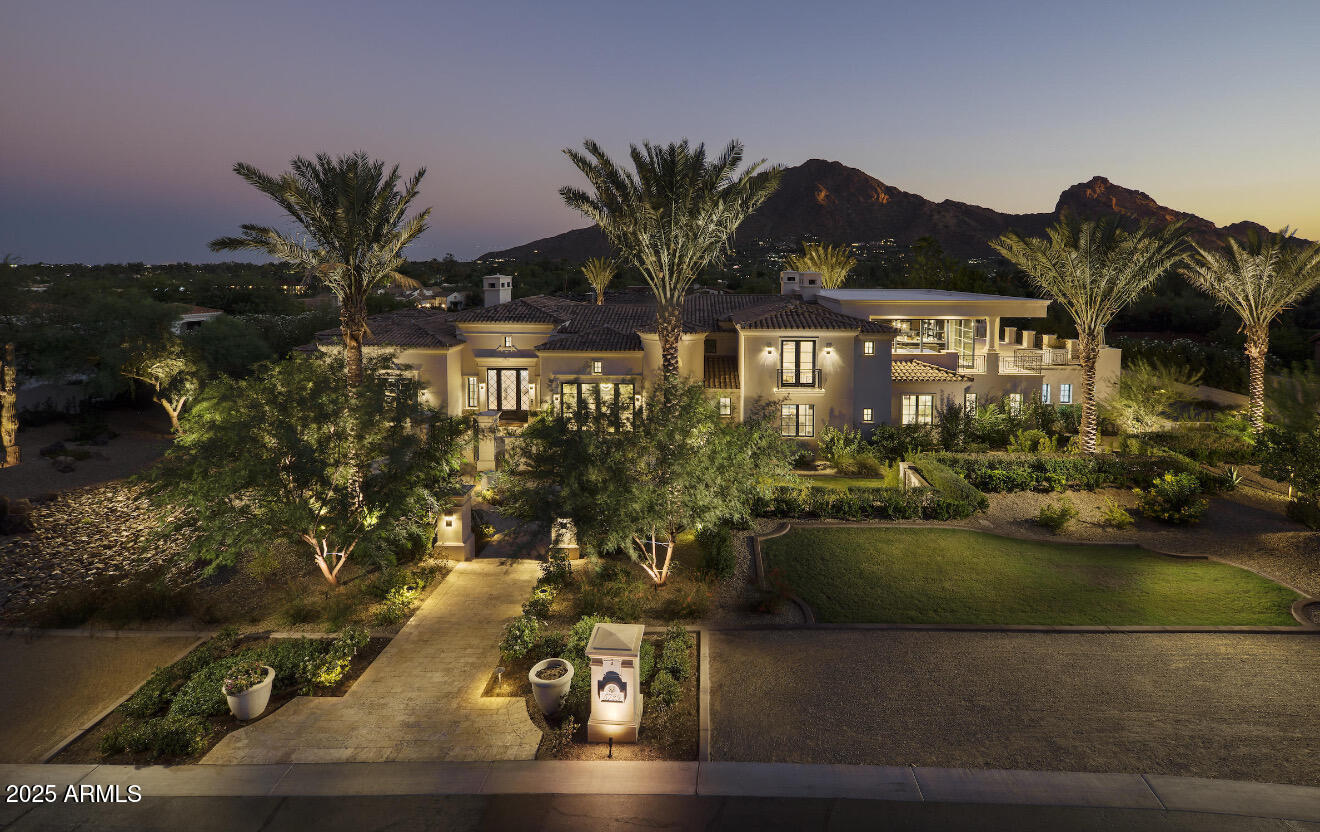Highly sought after Paradise Valley location in prestigious Club Estates neighborhood! Perfectly positioned on a north/south lot at the base of Mummy Mountain, this estate offers unmatched privacy with intimate views of Camelback Mountain and unobstructed sunsets. Designed for both comfort and entertaining, the home features expansive pocket doors creating seamless indoor-outdoor living, a negative-edge pool, massive wraparound view patio featuring a bar and lounge area, and multiple dining areas including one with a fireplace. Disappear in the private movie theater, share your favorite vintage from the temperature-controlled 1,000-bottle, stone wine cellar, or host gatherings with ease in the chef's kitchen. A gated motor court and 6-car garage complete this rare retreat.