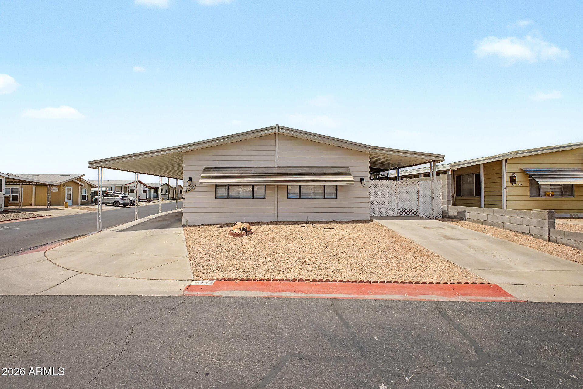 Two bed, 2 bath 1344 square foot mobile home on owned land. Discover all the charm of this corner lot home! The interior showcases thoughtfully designed living spaces with wood-look flooring, tons of natural light, vaulted beamed ceilings to add character, new blinds, and freshly painted interior. The kitchen offers white shaker cabinets, quartz countertops, and built-in appliances. Get a good night's sleep in the main retreat, offering a closet with mirrored doors and a private bathroom with dual sinks for extra comfort. This home features a workshop + mancave or she shed and storage for added convenience. The enclosed patio is the perfect spot for enjoying your morning brew and peaceful evenings. Large carport parking space and RV gate!