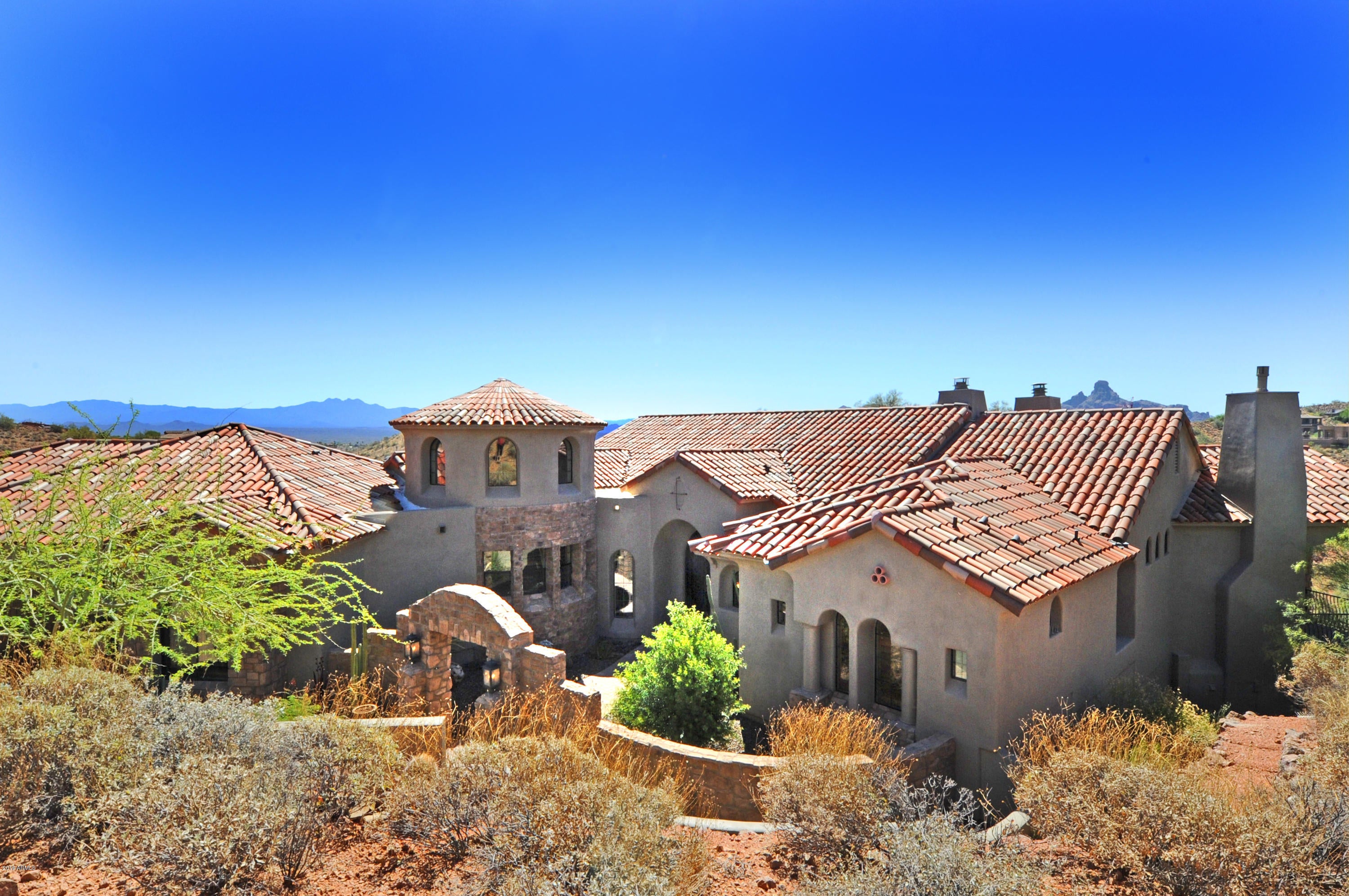 Very private custom home in beautiful Firerock C.C. This 5 B/R and 5.5 bath home is perfect for indoor or outdoor entertaining. From the large great room open up the 16 ft. infinity doors to expansive 93 ft.covered patio with 2 fireplaces,built in BBQ, great views of 16th fairway, mountains and city lights. Chefs kitchen has stainless sub-zero fridge, Wolf gas cooktop, dual ovens, large island and breakfast area. Beautiful master has fireplace, sitting area and access to covered patio. All bedrooms are en-suite.  Lower level has large bonus room and 4th bed room with access to covered patio and heated spa and pool. 5th bedroom has private outside entrance by pool. Over $200,000 spent on remodel and upgrades since 2014. Golf Club membership is optional.