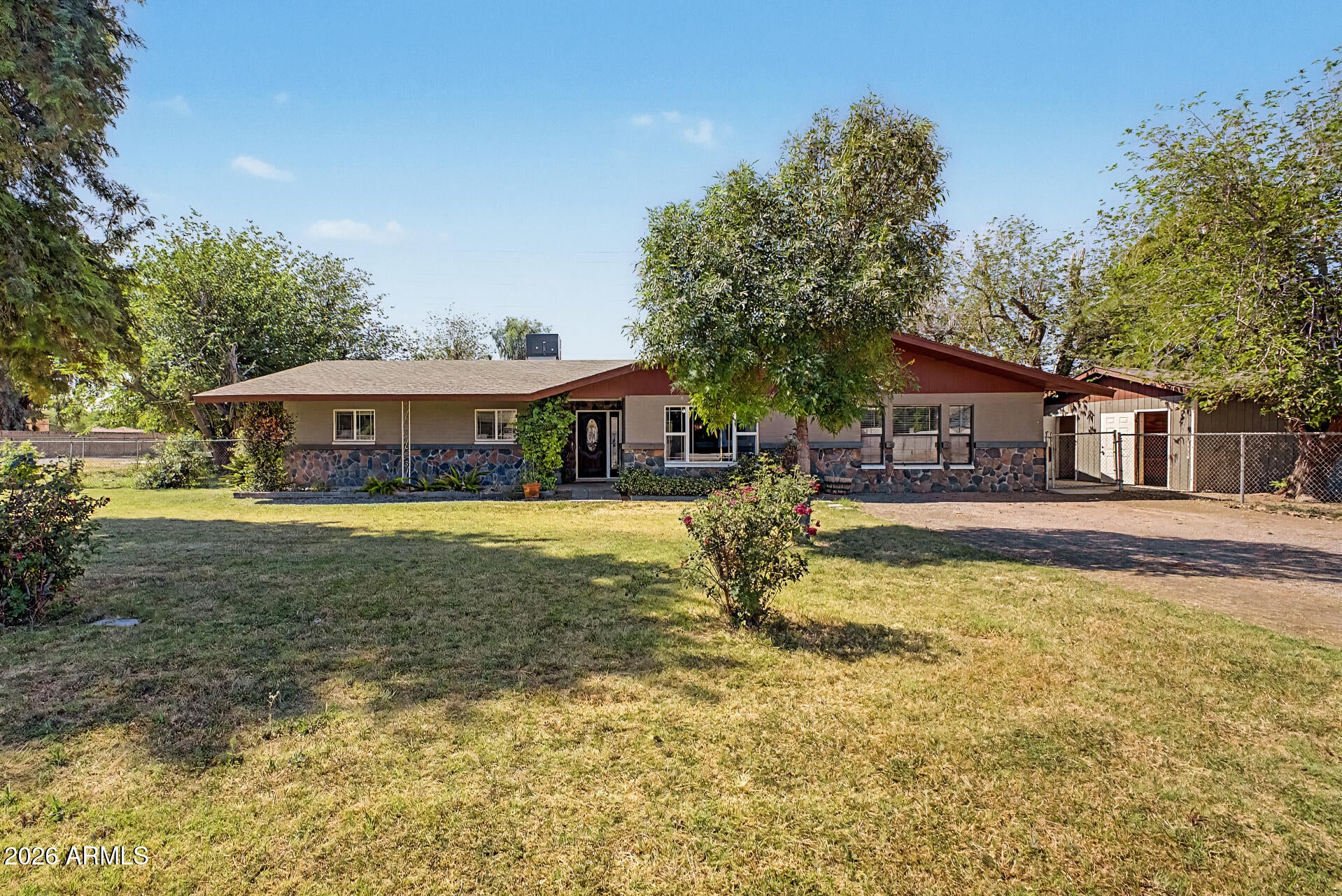 Nestled on a HUGE 1.10-acre corner lot, this beautifully crafted 5-bedroom home offers the perfect blend of space, comfort, & timeless country charm! Riding trails right outside your yard, horse pasture and chicken coop. Tons of mature fruit trees and large shed. Large living room with a stylish two-tone palette, impressive great room, paired with a cozy fireplace, provides an excellent setting for relaxing evenings or entertaining. Exposed ceiling beams, wood-look flooring, abundant natural light, & ceiling fans add warmth & character throughout. Modern kitchen has high-end SS appliances, walk-in pantry, granite counters & a center island. Owner's retreat continues to shine with a barn door to the walk-in closet & a lavish ensuite complete with chandeliers. Perfect Gilbert location! A major highlight is the 2nd main bedroom with its own bathroom, perfect for guests or multi-generational living. Massive backyard provides a covered patio, storage shed, & horse stalls. This equestrian property has it all!