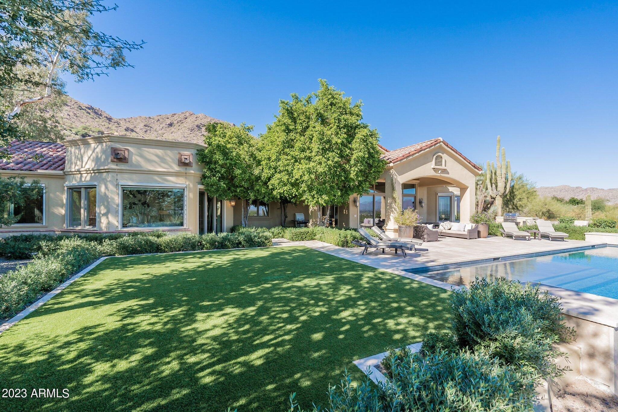 What a find! Incredible Hillside Location with Sweeping Views of both Mountain and City Lights. This Charming Family home is all one level with no steps! Many recent updates to kitchen and master suite/bath.  Walls of glass allows a plethora of natural light bringing the outdoor spaces truly part of your living space. The home features 4 large bedrooms, plus office/den with built-ins and direct outside access, off the master bath a generous work out room this could become a second private office or an additional large closet off master.
The kitchen remodel features 6 Burner Wolf Gas Stove with additional griddle, two ovens, Subzero Refrigerator and additional freezer drawers and ice maker. Two concrete sinks, large island with seating area and additional deep drawers for storage, wood flooring. Kitchen opens right up to the spacious Family Room with wood flooring and beamed ceilings.
Gas fireplace to gather in front of on cool winter evenings. This open space creates the perfect casual living space. The Primary suite creates the perfect sanctuary after a long day, the bathroom was recently renovated with modern sleek lines and tons of natural light. Some of the features include a soaking tub, oversized shower, dual vanities with extra counter space. There is even an outdoor shower for those warm summer nights. 
The formal living room features barrel ceiling, wood floors and massive gas fireplace and mantel. Look straight thru to the stunning back yard featuring the recently added negative edge pool and spa which appears to fall off the hillside. For those cooler winter evenings light your gas firepit and enjoy watching the sunset with different Brillant colors in the sky every evening. Grab some steaks and cook out on your large gas BBQ island. You will love entertaining with the great flow of this home many doors to open from kitchen and living space to rear yard as well as the front enclosed courtyard which features massive tree and water feature, as well as many planters and lush landscape bringing the outdoors in. This is a home that truly must be seen to appreciate the panoramic views and privacy you will feel.