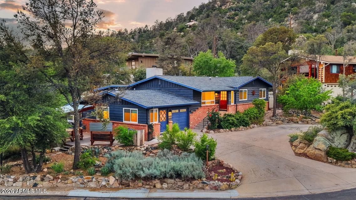 Classic Mid-Century Modern home in one of Prescott's most sought-after neighborhoods. Surrounded by boulders and pines on a quiet cul-de-sac, located just one mile from the iconic Thumb Butte Trail. This residence features a great room floor plan, highlighted by a charming brick fireplace and an original built-in display cabinet that adds character to the dining area. The light-filled kitchen is both functional and inviting, offering newer appliances, generous counter space, and ample storage. The refreshed primary suite provides a comfortable retreat with a beautifully updated bathroom boasting a custom-tiled walk-in shower. The junior suite has also been thoughtfully updated, complete with its own updated bathroom and walk-in shower. A standout feature of the home is the bright and airy studio/sunroom, along with the third bedroom and half bath, currently used as an office. With a separate entrance, this flexible space is perfect for guests, a home office, art studio, or private retreat. Extensive updates enhance the home's appeal, including upscale flooring throughout, newer HVAC, dual-pane windows, a tankless water heater, and a water purifier. The roof was replaced in 2018, offering added peace of mind. The lovely BBQ/Party Patio is perfect for entertaining, any time of the year. The property is landscaped and ready for summer planting. Fruit trees include Apple, Peach, Apricot and Almond. A circular driveway allows for easy entry and added parking.