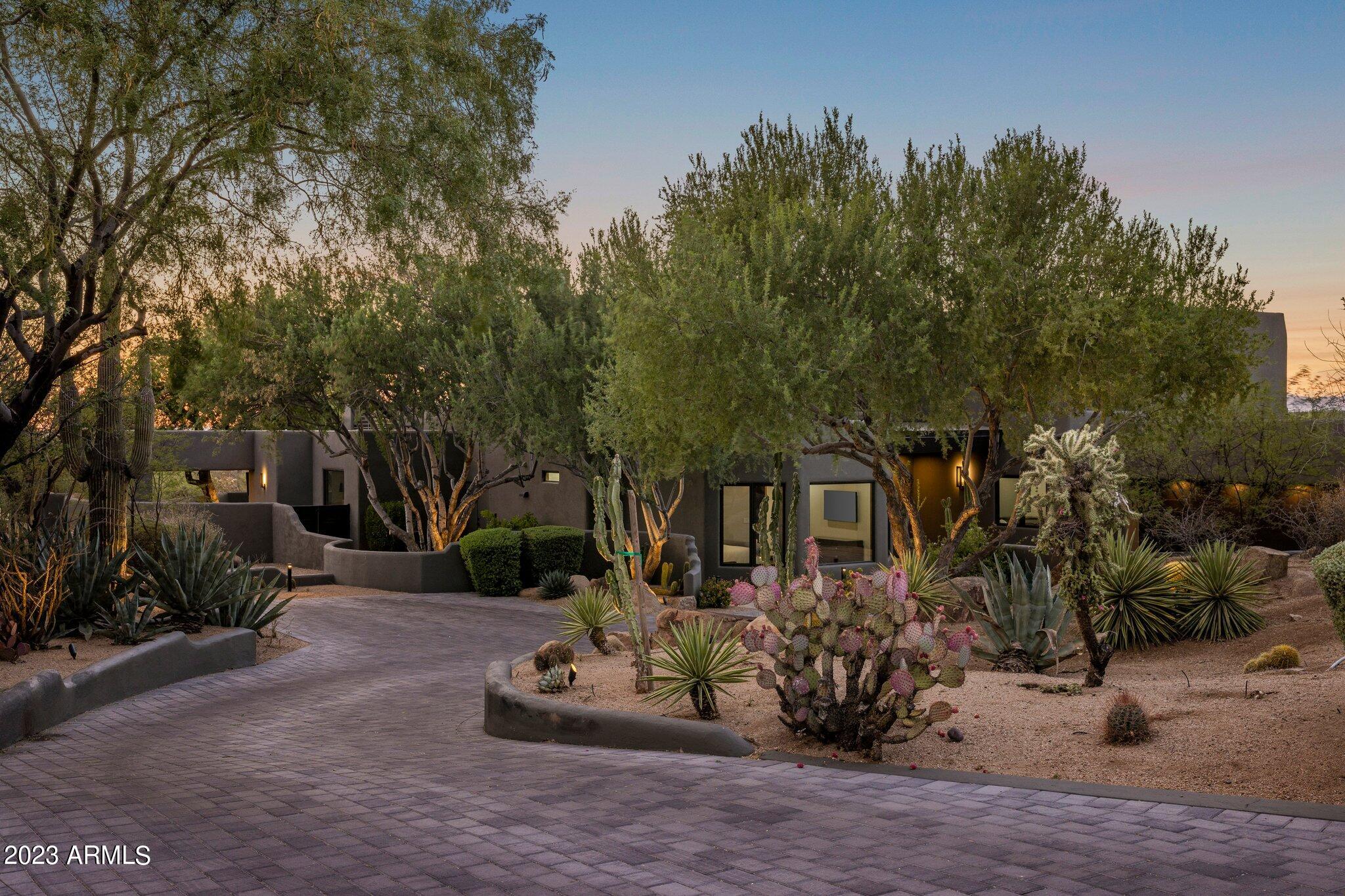 Nestled within the prestigious Desert Highlands, a community lauded by Forbes as one of the Top 20 most exclusive golf and country clubs in the U.S., lies a home that embodies modernity, casual elegance, and Southwest integrity. This residence sprawls across almost 1 acre of land, offering an unparalleled living experience amidst the breathtaking Arizona landscape.

As you step into the foyer, you are greeted by an abundance of natural light that fills the living room, creating an inviting ambiance that beckons you to explore further. The gas fireplace features a marble surround and emanates warmth and sophistication. Panoramic vistas extend from this vantage point, encompassing the inviting pool area and the expanse beyond.

This residence boasts two Principal suites on ... MORE the upper level, each with its own private balcony providing awe-inspiring views that sweep from majestic Pinnacle Peak to the mesmerizing city lights. Downstairs an additional two spacious bedroom suites await, one boasting a separate entrance and an adjoining office area, offering versatility and convenience to suit any lifestyle.

Throughout the residence, solid hardwood floors underfoot accentuate the elegance and timeless charm of the home. The heart of the property lies in its Chef's kitchen, meticulously designed with leathered granite counters and a spacious center island. Top-of-the-line appliances include a steam oven, a second oven, a subzero refrigerator, and separate beverage drawers, while the Wolf range and convection cooktop cater to even the most discerning culinary enthusiasts. The adjoining eat-in kitchen and formal dining area provide the perfect settings for intimate gatherings or extravagant celebrations, each evoking a sense of comfort.

Entertainment reaches new heights in the dedicated theater room, where a cinematic experience awaits. For those seeking more leisurely pursuits, the large family room offers a haven of relaxation and amusement. Complete with a wet bar, a 900-bottle wine cellar, an ice maker, and a dishwasher, this area is an entertainer's dream. Pocket doors seamlessly blend the indoors with the outdoors, opening up to the meticulously designed backyard oasis.

Unwind in the splendor of your private resort-style sanctuary. The covered patio beckons you to savor al fresco dining, while the barbecue area invites you to unleash your culinary prowess. As the sun sets over the horizon, the fire feature casts a warm glow, complementing the soothing sound of cascading water. The inviting pool, surrounded by lush landscaping, invites you to cool off during Arizona's warmest days. 

Designed with the utmost attention to detail, this extraordinary estate boasts five A/C units, ensuring that comfort is never compromised, even in the wine cellar, where your finest vintages are safeguarded and perfectly preserved.

In the heart of Desert Highlands, this magnificent residence effortlessly blends modernity and Southwest charm, presenting an unparalleled opportunity to acquire a prestigious property in one of the most exclusive communities in Scottsdale. Whether you seek a resplendent full-time residence or a luxurious retreat, this masterpiece stands ready to embrace your unique vision of luxury living.