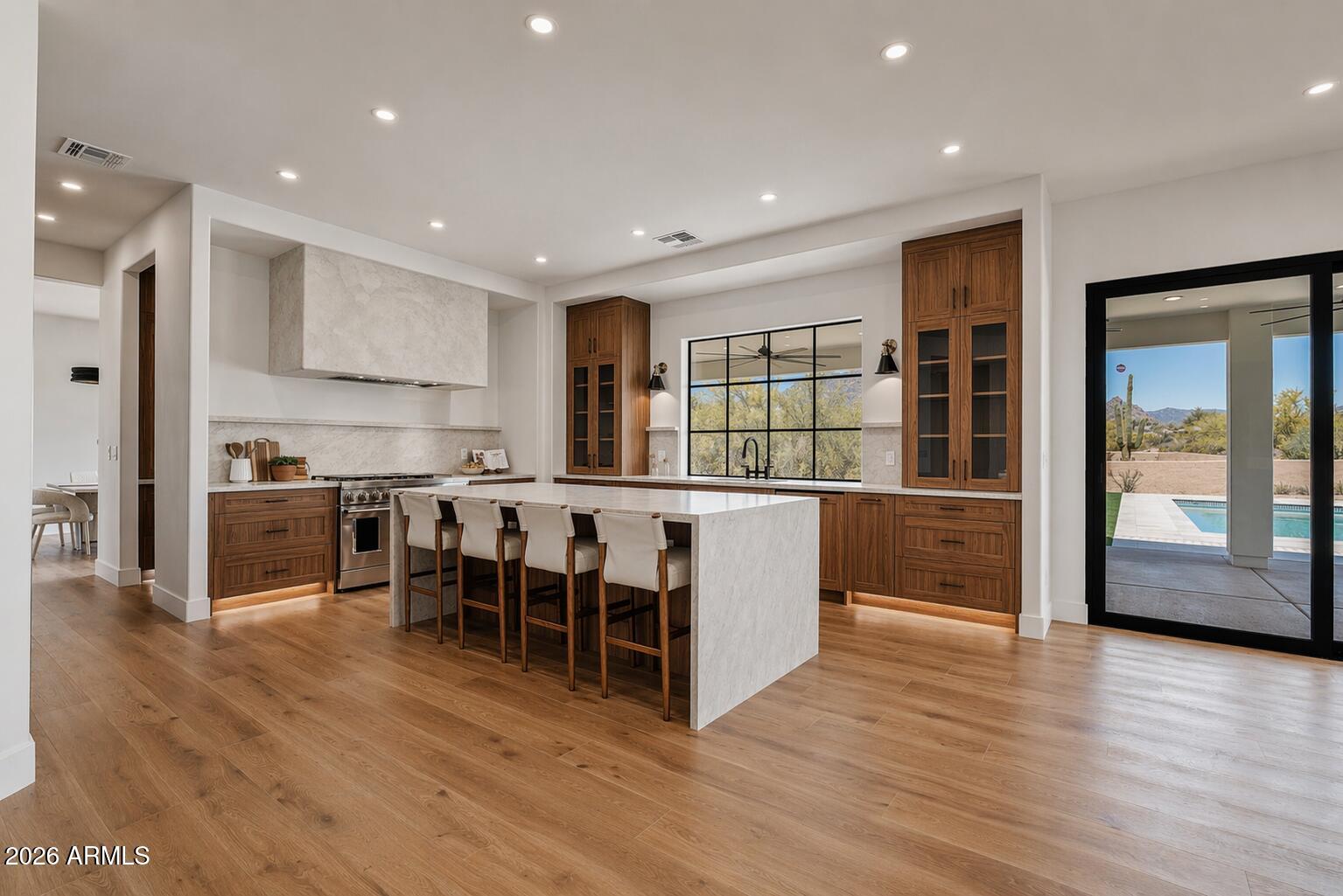 Completely reimagined Cave Creek estate on 1.15 acres, where mountain views, open desert, and privacy define the setting. A dramatic great room with soaring 20-foot ceilings and natural light flows into an expansive kitchen with custom cabinetry, Taj Mahal quartz, and a 48-inch range. A 15-foot collapsible slider opens to a newly built backyard with pool, firepit, and private pickleball court. Upstairs, the primary suite offers a quiet retreat with views. The detached 2,500 sq ft RV garage delivers exceptional scale for collectors, storage, or future use, complemented by a 4-car garage. No HOA and owned solar complete the offering.