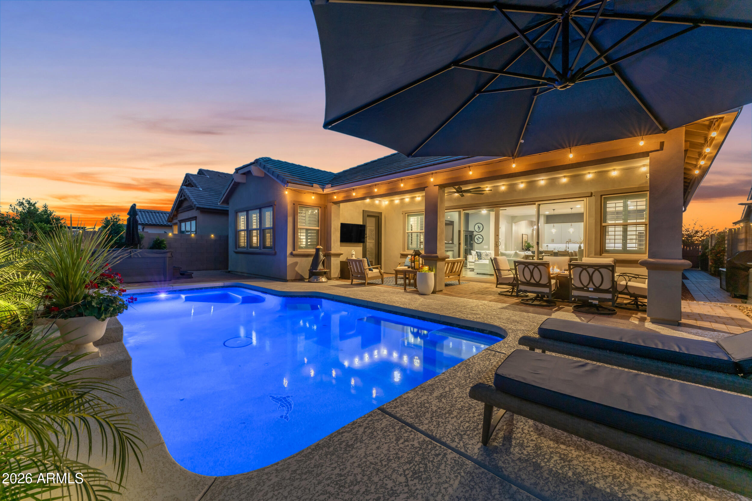 Enjoy all the amazing amenities Barney Farms in Queen Creek has to offer, including zip lines, walking trails, parks, fishing, kayaking and canoeing on the beautiful 22-acre lake, pickleball, bocce ball, basketball and sand volleyball courts, plus a large community heated pools and aquatic center for endless fun and recreation. Welcome to this stunning 4 bedroom, 3 bath home with a tandem 3-car garage that feels just like new without the long wait. From the moment you arrive, the cozy front porch and iron security door invite you in. Inside, you are greeted by a bright foyer with two-tone paint and designer touches that carry through the home, along with beautiful plank tile flooring and plantation shutters. The kitchen is the true heart of the home, made for gathering, with 42-inch cabinets, a large quartz island, quartz counters, gas stove, wall oven, and a spacious walk-in pantry. The great room offers a built-in wall unit with a fireplace and plenty of space to relax or entertain, while the dining area is perfect for hosting. Large atrium sliders open to an amazing backyard with a heated saltwater pool, fountain, colorful lights, also option for volley ball netting set up, and plumbing ready for a spa, and paved side gates. The primary suite is a peaceful escape with its own exit to the yard, a large closet, soaking tub, and walk-in shower. A standout feature is the private living retreat with a bedroom, and bathroom, perfect for guests or extended family. With added upgrades like rain gutters, epoxy garage floors, tankless water heater, and water treatment system, this home offers comfort, style, and space in one beautiful package.