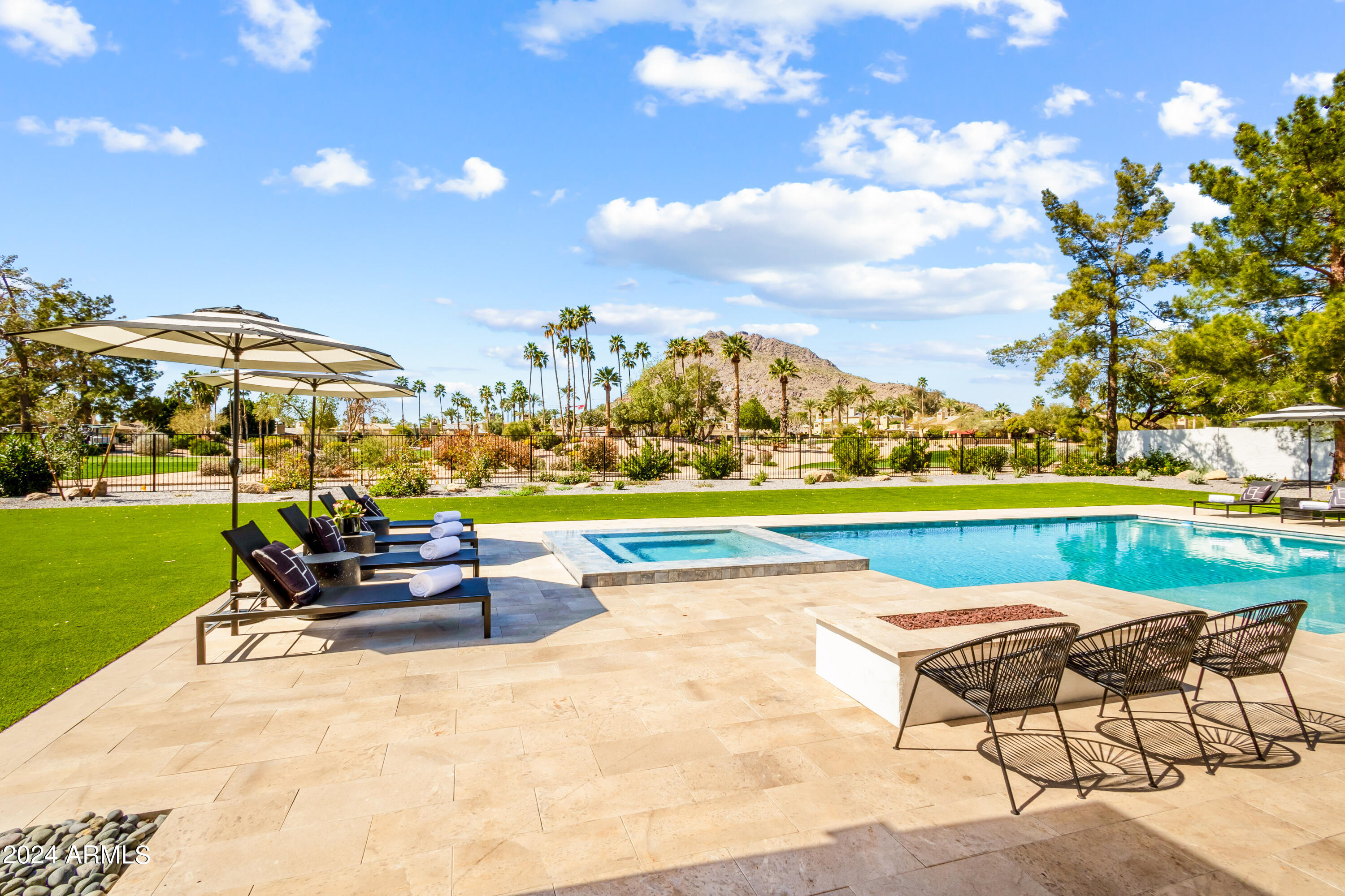Modern single-story estate with breathtaking Camelback Mountain views! This lot over an acre sits in the Hopi district w/5 beds & 4.5 baths. Natural light, high ceilings with skylights, white oak flooring, & large sliders meet this open concept living, dining, and kitchen. Chef's kitchen features two-toned custom cabinets, high-end appliances, kitchen island, & oversized pantry w/2 ovens, setup for additional fridge, & extra storage. Primary suite includes sliders w/private entry to backyard, fireplace, large bathroom w/dual sinks, freestanding bathtub, enclosed toilet, large shower, and walk-in closet. Backyard backs the Phoenician golf course with soaring mountain views, custom pool/spa with expanded deck, firepit, covered patio, turf, & desert landscaping. Home includes attached guest quarters with kitchenette, rooftop deck with firepit and setup for outdoor TV, and utility room with double washer/dryer units. Prime location to enjoy the best resorts, golf, shops, and restaurants that Arcadia and Scottsdale offer.