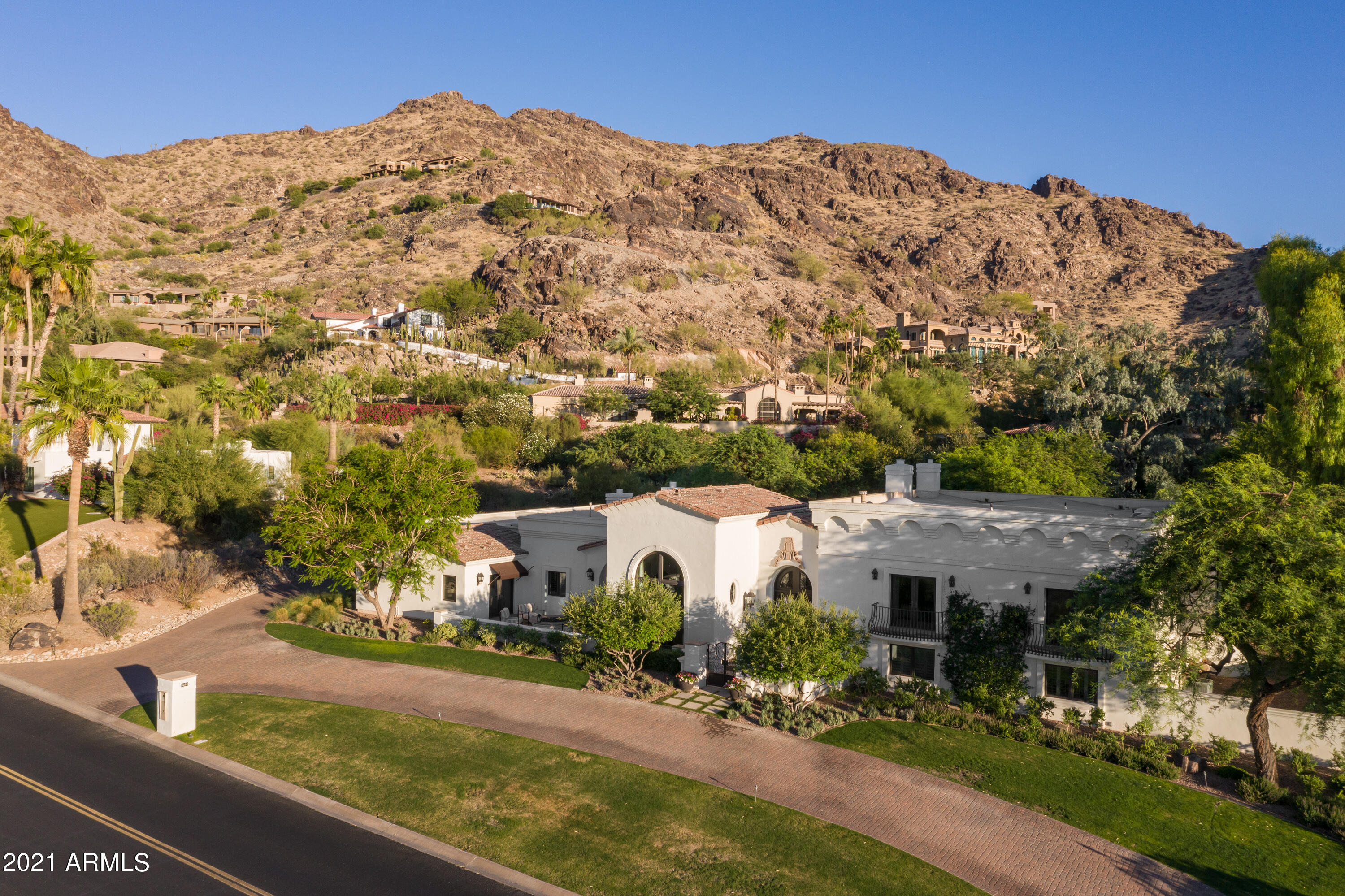 This exquisite home sits in an extraordinary setting on the western slope of Mummy Mountain. Designed by the highly respected and extremely talented Mark Candelaria, the home perfectly combines elegance and comfort. The high style begins with the gracious courtyard entry and leads into a home loaded with impeccable taste. The spacious island kitchen has quartz countertops, beautiful custom cabinetry, double Viking ovens, two Miele dishwashers, Subzero refrigerator, and an extra prep sink in the island. The great room has a fabulous statement fireplace and fully retractable automated glass doors that seamlessly merge indoor and outdoor living, the living room and dining room are both gorgeous, there's a phenomenal office that will make working from home the preference, and the master....... retreat has a lovely sitting area, fireplace, stunning bathroom, and separate his and hers closets, offering a dream worthy space to begin and end each day. Custom furniture grade cabinetry, impressive lighting, Caesarstone countertops, Portuguese limestone flooring, and a control 4 home automation system are just a taste of the special features in this spectacular estate, and the grounds are absolutely magnificent with a heated pool and spa, lush manicured lawns, a poolside ramada and additional covered patio both with fireplaces, built-in barbecue, and breathtaking mountain views. Sitting on an acre lot with a three car garage, not a detail was overlooked in this remarkable residence that's full of tasteful grandeur!