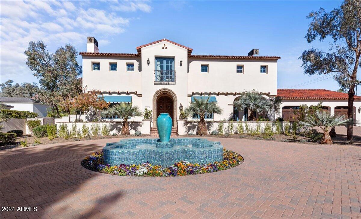 Experience unmatched privacy and elegance in this Santa Barbara Estate. Nestled in the coveted Arcadia neighborhood, yet offering the seclusion reminiscent of Paradise Valley, this meticulously designed Spanish Colonial Revival estate is a masterpiece of timeless elegance and modern comfort. Tucked at the end of a serene cul-de-sac, a long private driveway leads through a gated entrance, unveiling a circular drive centered around a stunning quatrefoil fountain. The beautifully landscaped front yard, additional parking, and a formal rose garden create a welcoming ambiance. The grand portico entrance features custom 10-foot mahogany arched doors framed by an intricate cast-stone surround. Inside, 12-foot beamed ceilings, imported terra cotta tiles, and rich hardwood floors set the stage for a luxurious lifestyle. Solid mahogany interior doors add warmth, while double-pane aluminum-clad French doors and windows flood the home with natural light and provide breathtaking views of Camelback Mountain. Every detail has been thoughtfully designed, from custom cabinetry throughout to handcrafted wrought iron light fixtures. The family and living rooms showcase custom plaster shell niche caps and cast-stone fireplace surrounds. Imported, hand-painted decorative tiles and murals add vibrant artistry to the home. The gourmet kitchen is a chef's dream, featuring limestone countertops, a Sub-Zero refrigerator, and a La Cornue stove. The garage is prewired for an electric car charging station, ensuring convenience for modern living. Step outside into your private oasis, complete with a sparkling pool, spa, and tranquil water features that transform the backyard into a serene retreat. This Santa Barbara estate perfectly balances classic sophistication with contemporary amenities, making every day feel like a luxurious vacation. Don't miss your chance to call this breathtaking property your own.