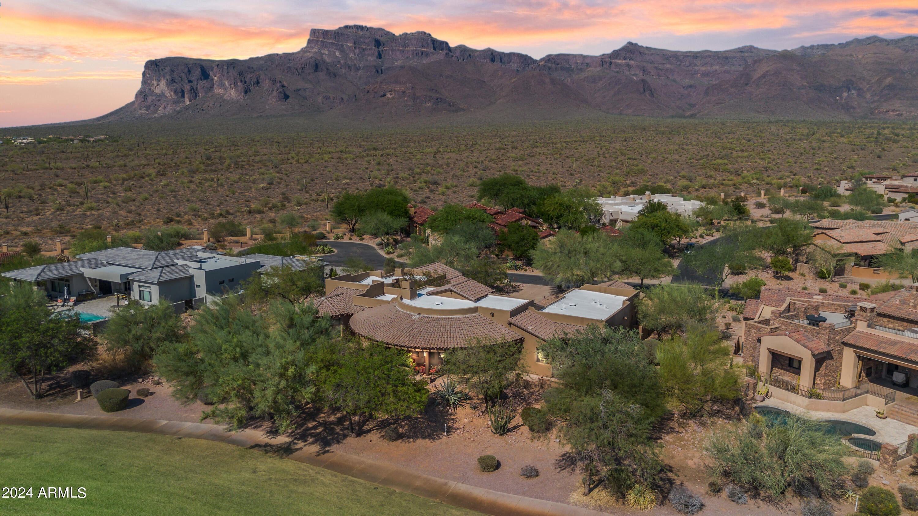 MOUNTAIN AND SUNSET VIEWS! Remarkable residence located in the prestigious Superstition Mountain Golf and Country Club situated at the foot of the majestic Superstition Mountains. Overlooking the 6th fairway of the Prospector course, this course was featured in the 2023 LPGA tour! A 24-hour secured guard gate leads you to this hidden gem of a neighborhood featuring world class amenities including two Nicklaus designed golf courses, spectacular clubhouse with fine dining, fully appointed sports club, a resort style pool and more. This home is immaculate with so many custom features and upgrades, you truly must see to appreciate. You'll love the exterior stone accents, private courtyard, outdoor kitchen & guest quarters all on one level. The captivating interior boasts archways, 8' alder wood doors, tile flooring, soaring ceilings, & surround sound throughout this well laid out split floor plan. An oversized two car garage just off the laundry room and connected to the main house includes overflow AC keeping it cool on those hot summer days as well as epoxy floors. A single car garage is located adjacent to the guesthouse. Additional amenities include a natural gas Generac generator and full house water softener.

You are welcomed through the large front door into the great room with awe inspiring views of the golf course, a massive custom fireplace, and 14-foot ceiling. The chef's kitchen boasts Alder cabinets, granite, butcher block island, pantry and GE Profile refrigerator, gas stove top, oven and Advantium oven. Also featured is a stand-alone ice maker and wine refrigerator.

With a view of the courtyard, the formal dining room hosts a table that will seat 10 people, a hutch and buffet. A stylish powder room with glamorous fixtures welcomes your guests.

The huge Master Suite with gorgeous bay windows provides breathtaking mountain and golf course views to wake up to every morning, motorized privacy shades, sitting area, huge walk-in closet with custom shelving and W/D hook up. Remodeled master bathroom with tons of natural light includes double vanities, large walk-in shower, separate soaking tub and privacy room for commode. The adjacent Den/Office has custom built in desk, lighting, cabinets and separate exit to the back patio overlooking the golf course.

The 2nd Master Suite has a large walk-in closet and an exit to a private sitting area overlooking the golf course.

Privacy rules in this separate entry guest quarters offering a living room, a two-way fireplace, a wet bar w/cooler, a bathroom, & a walk-in closet w/stacked washer & dryer.

The outdoor kitchen includes a built-in BBQ, granite counter tops and seating, The large, covered patio offers room for dining and sofa seating to enjoy beautiful sunset views and city lights. Don't just imagine! See it! Some furniture also available via separate bill of sale.