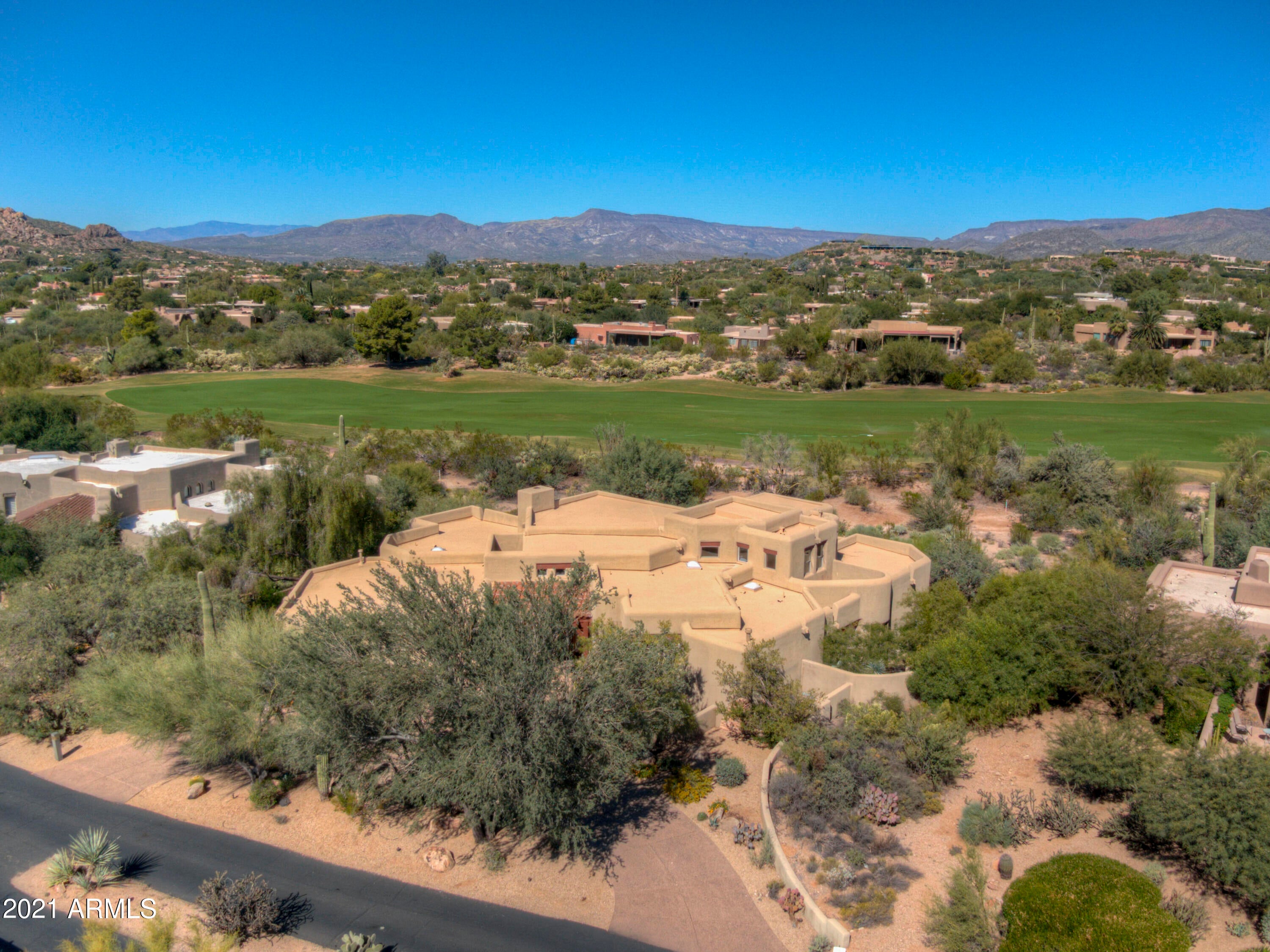 Quintessential Boulders home featuring warm architectural detail and outdoor living spaces. Tucked on away on a tranquil street with lush desert open space to the front and the 12th hole of the golf course to the back.  Grand entry with custom woodwork opens to living room with hardwood floors and grand stacked stone fireplace.  Generous kitchen offers plenty of room to accommodate eat in options.   Well thought out floor plan with 2 master suites, both offering walk in closets and en suite bath.  3rd bedroom is currently being used as an office, spacious and bright.  Upstairs to guest quarters with private view balcony.  Tremendous patio with built in BBQ grill and welcoming fireplace surrounded by golf course and sweeping mountain views.