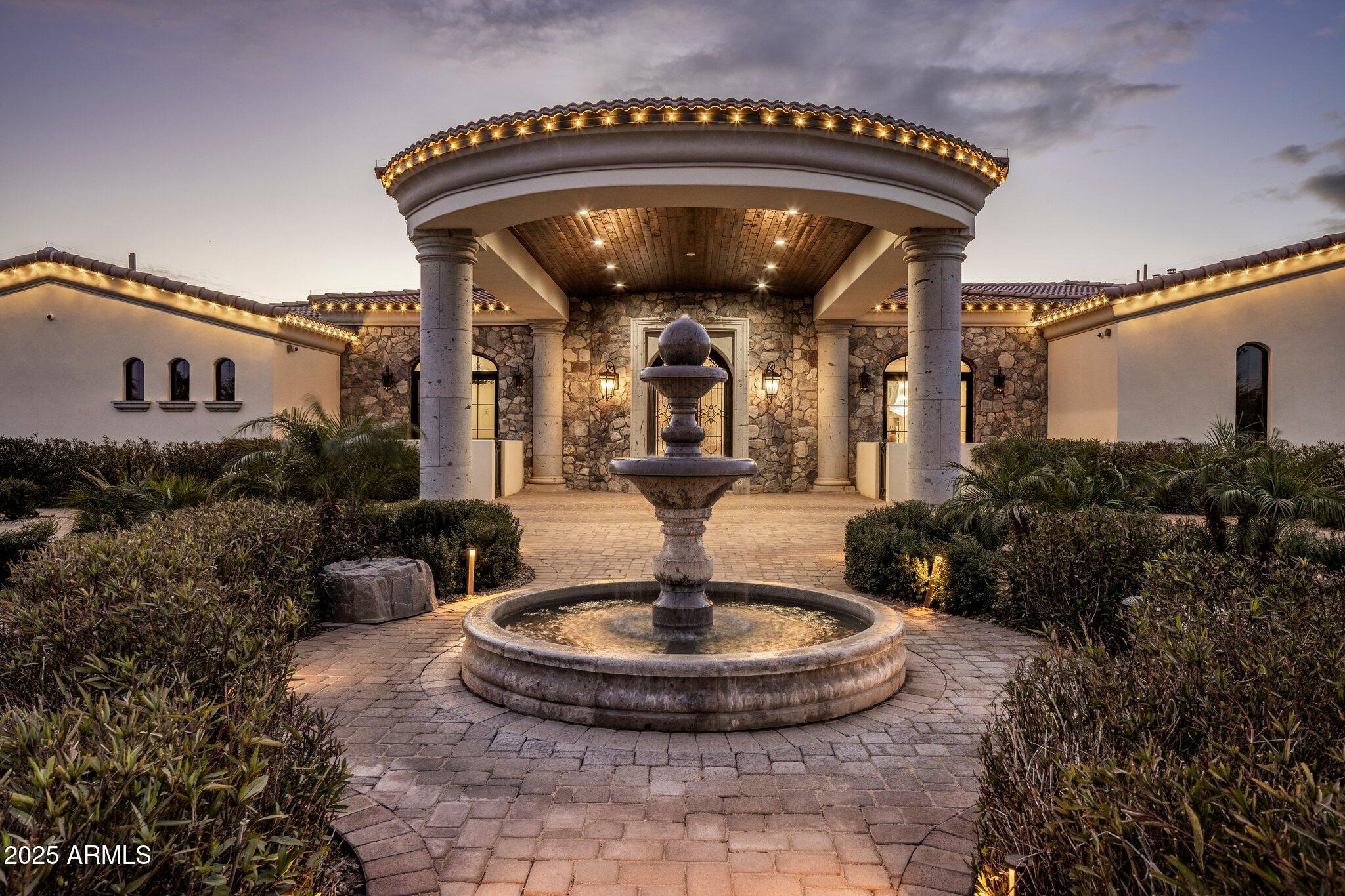 Indulge in the epitome of luxury living with this breathtaking residence. As you approach, the curb appeal captivates you with its exquisite opulence, as you drive under the large portico adorned with large Cantera stone pillars and a beautiful tongue & groove wood ceiling. Step inside the 10-foot double metal and glass entry doors, setting the stage for the grandeur that awaits within. The main house offers 4 bedrooms, 5 bathrooms, plus a powder room for the convenience of guests. The guest house boasts 924 sq ft, offering a large bedroom, bathroom, living room and full kitchen. Enter through the grand foyer, boasting soaring hand-painted Groin arched ceilings and rich maple wood flooring creating an immediate sense of elegance. The formal domed dining room, adorned with similar hand-painted ceilings, invites you to savor refined meals and opens to a private courtyard, seamlessly blending indoor and outdoor living. A versatile office study, doubling as a potential fourth bedroom, offers coffered ceilings and double-crowned ceiling accents, plus a full bathroom of its own. This room opens to yet another charming courtyard, providing a tranquil and private retreat. As you continue into the living area you will experience an open living room with the main focal point being the large gas fireplace adorned with a large Cantera stone mantle and custom-made gate. The large sliding glass wall lends to the backyard oasis, offering stunning views of Camelback Mountain. 

You'll love the custom kitchen, the true heart of the home. This culinary delight offers an expansive granite island, pendant lighting, ivory cabinets, and exquisite details like a custom hood vent and ornate backsplash. Other impressive upgrades include a pot filler, high-end appliances, including a 48" Wolf Series gas range and a Sub-Zero integrated freezer and refrigerator. Designed for entertaining, the butler's pantry compliments the kitchen, providing additional cabinetry, countertop space, a sink, a second dishwasher and an additional full-size refrigerator. 

The powder room is a work of art with custom textured walls and a hand-selected onyx stone sink, adding a touch of sophistication.

As you walk down the hallway you will be met with the lavish 300 bottle climate-controlled wine room, which is a piece of art by itself.

You will then enter the bonus living area, perfect for family movie nights. The additional bedrooms, which are generously spacious, offer a haven of comfort with private en-suite bathrooms and walk-in closets. The tranquil primary master suite is the highlight of this magnificent home. A secluded primary wing retreat, featuring over 2000 sq ft. With automatic shades, a soothing electric fireplace, and direct access to the backyard oasis, you might never want to leave. The primary en-suite is a true sanctuary, offering two private water closets, separate sinks, and custom large walk-in dual closets. The grand jetted soaking tub, adorned with an ornate chandelier, provides a luxurious space for relaxation.

Additional features of the primary en-suite include an expansive walk-in steam shower, a separate washer/dryer, and an extended nook area that can be customized for various purposes, such as a gym, nursery or office space.

Step outside to the backyard, a true paradise designed for leisure. An expansive covered patio with a tongue and groove ceiling, fans, and a misting system beckons you to unwind. The 45 ft sparkling pool and infinity edge hot tub offer a refreshing retreat after a long day. For golf enthusiasts, two putting greens await, adding a touch of recreation to the outdoor haven.

Overlooking the pool, a stately ramada area becomes the focal point for entertaining, complete with a cozy fireplace and a gas grill. This outdoor space seamlessly combines luxury and leisure, providing a perfect setting for gatherings.

The property extends its hospitality with a 924 sq ft guest house- a one bedroom retreat with two bathrooms, a full kitchen, and a walk-in closet. Adorned with porcelain tile in a herringbone pattern, this space effortlessly combines elegance with functionality, offering a stylish living experience for guests.

For automotive enthusiasts, the climate-controlled 1460 sq foot 4-car garage is a dream. With metallic epoxy flooring, built-in storage space and an extended workspace, this impressive garage caters to both functionality and aesthetics. A private paved auto courtyard adds convenience, along with 2 RV gates and a 300 sq ft storage area.

In summary, this residence seamlessly combines architectural precision with 6113 sq ft of opulent living area in the main house and 924 sq ft of guest house area. There is over 10000 sq ft under roof area. Every detail has been meticulously crafted to create a haven where luxury, comfort and style converge, offering an unparalleled experience.