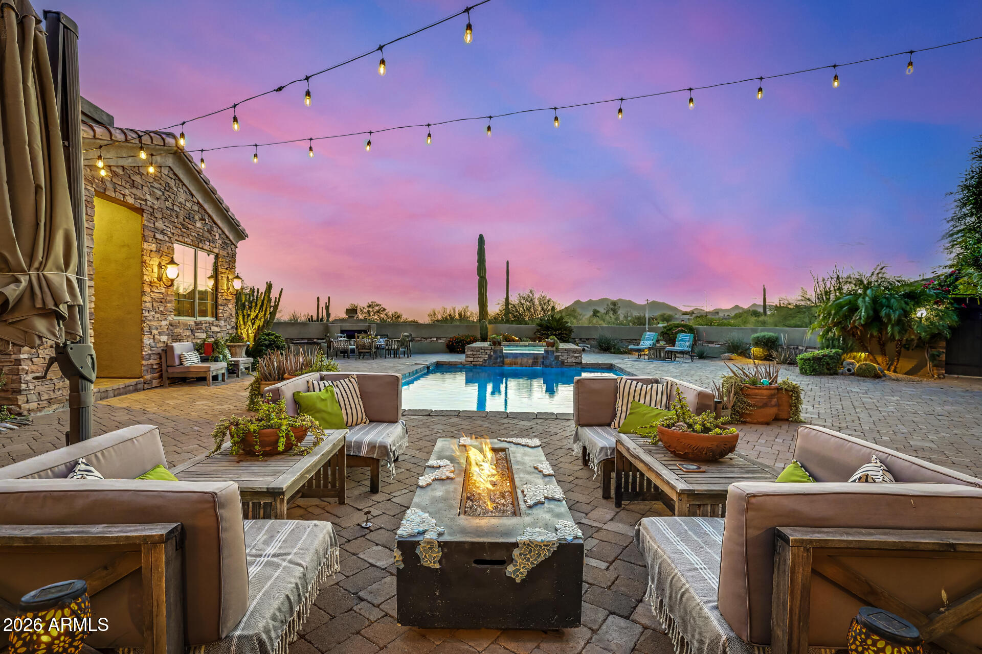 Stunning Black Mountain views from this custom 5BD, 4.5BA home with Casita in Cave Creek, featuring a Viking iron automated driveway gate, paver stone driveway, and gated courtyard leading to striking wrought iron and glass entry doors. Perfectly positioned away from street noise and offering direct backyard access to Cave Creek Regional Park trails. Inside, enjoy 10' alder wood doors and cabinetry throughout, timeless travertine flooring in main living areas, and wood-like ceramic flooring in bedrooms. The dramatic rotunda living room showcases a 25' ceiling, cozy fireplace, and three French doors that open seamlessly to the 800 sq ft covered travertine patio and paver courtyard. The resort-style backyard features a sparkling pool with waterfall spa, creating an ideal indoor-outdoor living experience. The private casita, accessible from the courtyard, is perfect for guests, a home office, or multigenerational living. The home also offers a formal dining area with bar and pantry adjacent to a gourmet chef's kitchen complete with a 7' granite island and vegetable sink, Wolf 6-burner gas stove with griddle, grill and pot filler, professional hood, Sub-Zero stainless steel refrigerator, RO water system connected to Sub-Zero ice maker, and a temperature-controlled wine cellar. The luxurious primary suite features its own fireplace, breathtaking pool and mountain views, patio access, and a built-in BBQ. The spa-like bath includes a soaking tub, separate rain shower, dual granite vanities, bidet, and spacious walk-in closet. Additional features include a newly finished epoxy 1,285 sq ft garage with ample storage. Major updates include: new tile and flat roofs (2024), Bosch dishwasher and water heater (2021), RO system (2025), ceramic wood plank flooring (2022), new paint, lighting, and ceiling fans (2025), landscape lighting (2023), patio sunshade (2021), irrigation and water lines front and back (2023), fresh exterior paint and stucco (2023), iAquaLink-controlled pool/spa system (2025), new pool/spa electrical and LED lighting (2026), new spa pump (2025), all plumbing valves and faucets replaced (2025), and new epoxy garage flooring (2026). This smart home is wired with hardwired and WiFi Ring cameras, a customer-owned security system, fire sprinklers, and sits on 1.86 acres of mature landscaping just minutes from Cave Creek amenities.