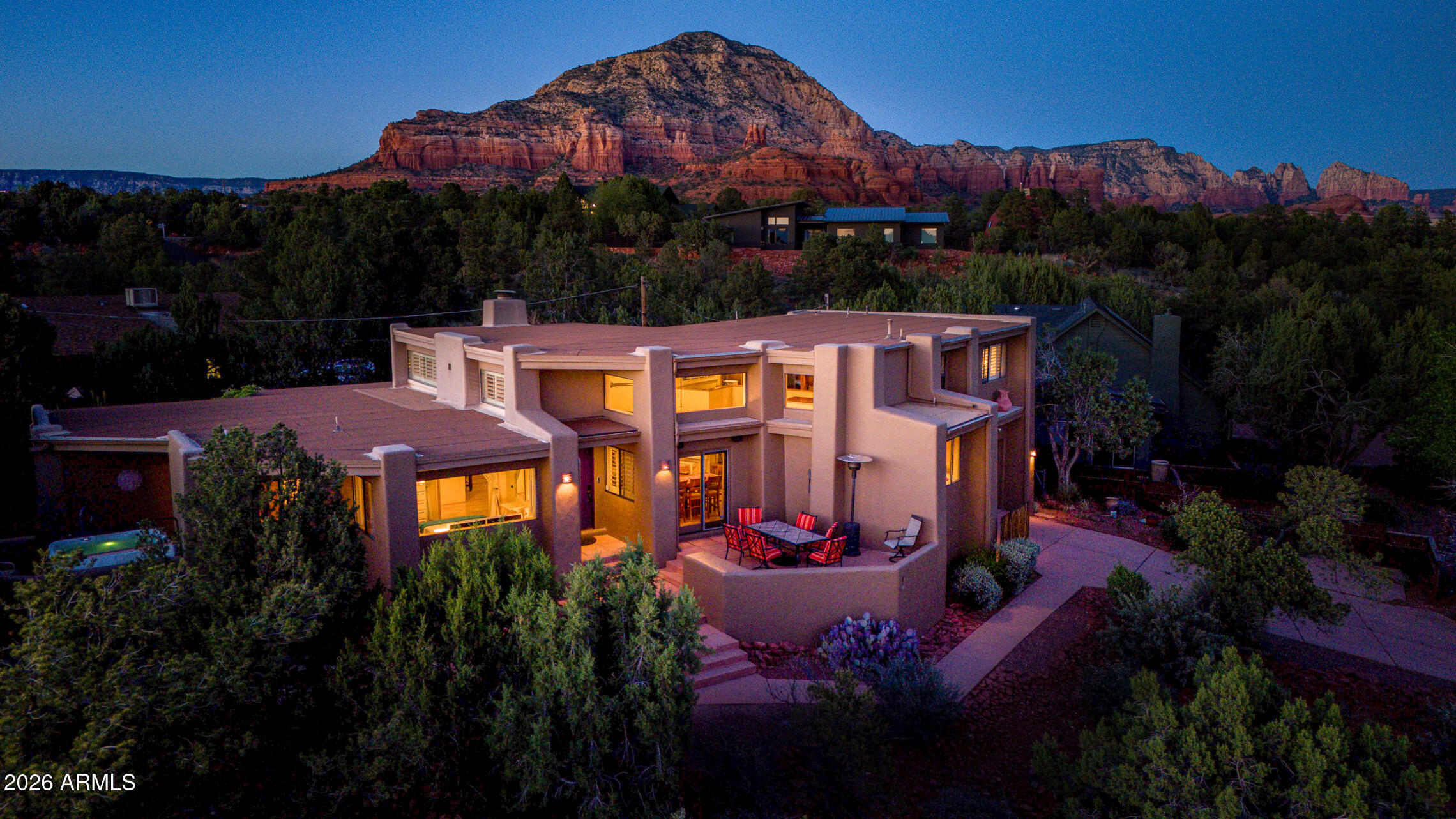 Rarely does a West Sedona property offer this much flexibility, charm, and income potential in a single package. Fully equipped and furnished and rich with modern Santa Fe Pueblo character, this 4-bedroom, 2-bath home is 2,590 square feet on .40 acre lot. It is equally compelling as a full-time residence, luxury getaway, or high-performing vacation rental (see the attached top-tier short-term rental pro forma projecting over to $112,000 in annual gross income).

A sanctuary inside, with soaring wood-plank ceilings, clerestory windows, oak floors, and a dramatic floor to ceiling fireplace that create a warm, light-filled living space with unmistakable Sedona character... The entertaining-focused open layout flows easily into the dining area and kitchen, where granite countertops, abundant wood cabinetry, and a charming pass-through window to the outdoor patio dining space make hosting guests feel effortless.

The outdoor experience is one of Sedona's finest with multiple patios, decks, and balcony spaces designed for everything from quiet morning coffees to evenings with friends under the stars. A private spa/hot tub, covered trellis patio, outdoor heating, and spacious backyard create a setting that feels both relaxing and memorable for owners and guests alike and all with enough space for additions such as a pool, putting green, or workshop.

The inspired layout has three bedrooms and a guest bath on the main level and a spacious upstairs primary suite featuring a sitting area, dual closets, a huge bathtub, his and her sinks, and a private balcony with peak-a-boo views of Thunder Mountain. A loft with built-in cabinetry offers flexible space for an office, reading lounge, or studio. Nestled away on a quiet cul-de-sac, the property also includes a two-car garage, Tesla plug, extra side parking, and major recent improvements including a new septic system in 2021, energy-certified HVAC in 2023, and a new water heater in 2023.

The home is well stocked with everything needed for a successful vacation rental from furniture to linens and cookware and it is all included in the list price, (except the white piano). Want to do your own decorating? Not a problem, owner is happy to remove the current contents as well if you're not interested in keeping them. 

This is the kind of Sedona opportunity buyers can't afford to miss, whether you're looking for a full-time residence, a Luxurious getaway, or a top-tier vacation rental investment, this home is a charming, turnkey gem, ready to deliver immediately with long-term appeal on every level.