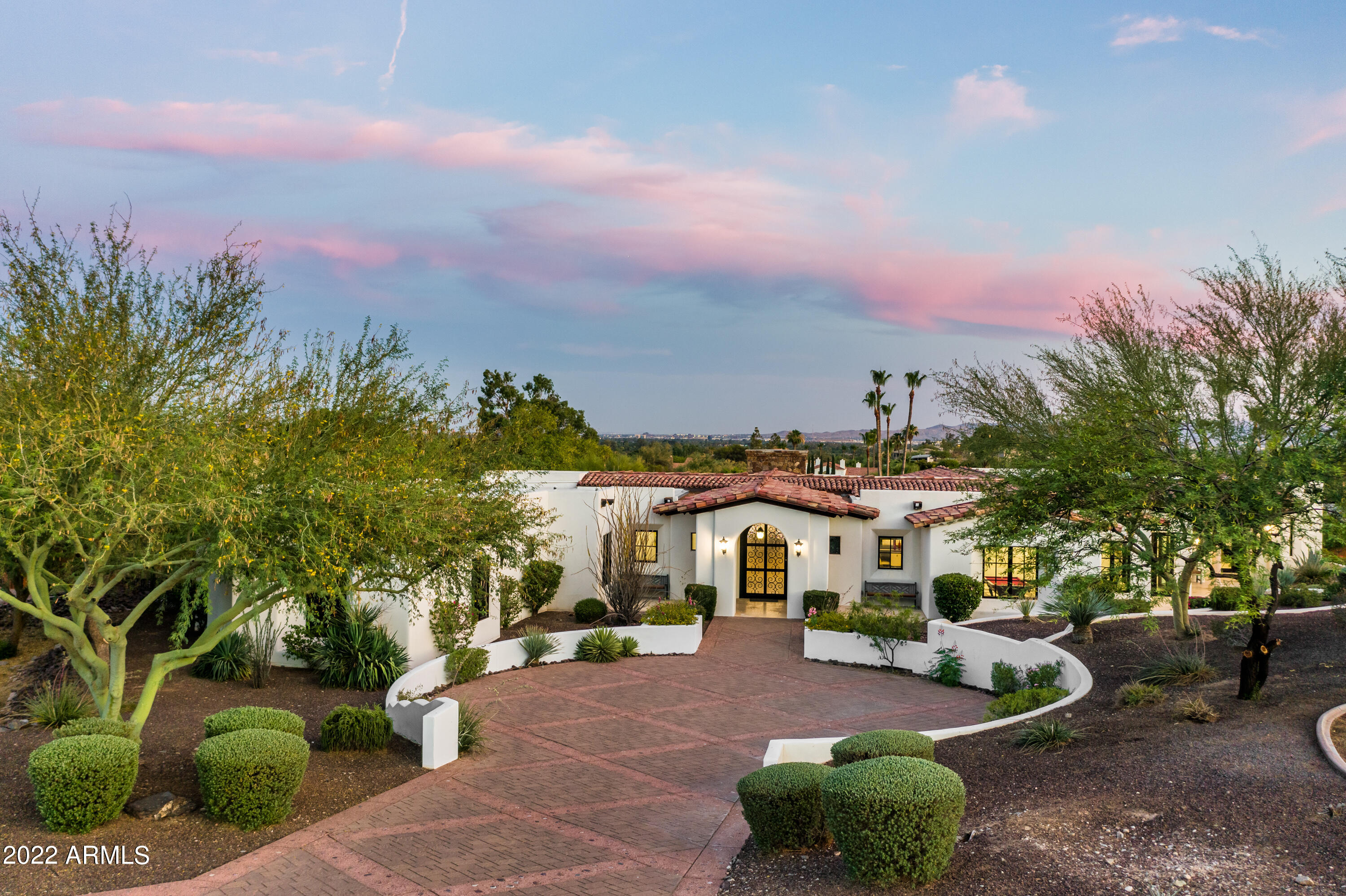 Enjoy high-style resort living at this gorgeous Custom Spanish Retreat in an exclusive Paradise Valley gated community. Gourmet kitchen with top-of-the-line appliances, leather finished granite island, and automatic retracting glass doors to patio perfect for entertaining. Custom walnut floor with Italian limestone inlay. Decorative iron fixtures, custom automation system, Bang Olsen sound system, and Cat5 throughout. Beautiful dining room, family room with double-sided stone fireplace, game room, and a large sunken bar. Basement with playroom/den, media room, exercise room. Oversized four-car garage. Dramatic sunset views embrace the Phoenix skyline around the amazing backyard with a negative edge pool, outdoor fireplace, and BBQ.