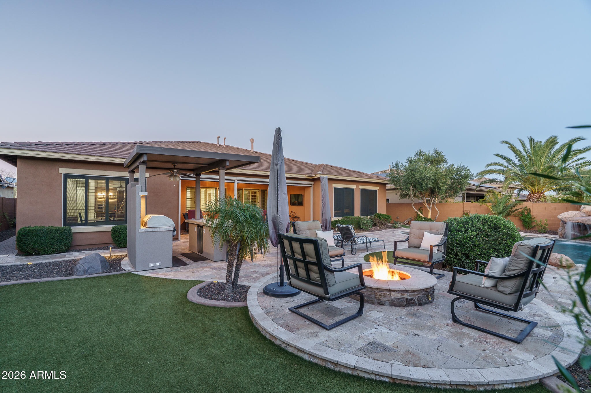 Behind the guard gates of Blackstone at Vistancia, this luxury home delivers elevated desert living paired with a true resort-style backyard. A private gated courtyard welcomes you into the foyer and flows seamlessly into the open-concept great room, where a stone-accent gas fireplace, custom media cabinetry, plantation shutters, abundant natural light, and motorized blinds create an inviting yet refined atmosphere. The chef's kitchen is thoughtfully designed with granite countertops, Thermador wall ovens, a gas cooktop, crown-molded cabinetry, a walk-in pantry, and a butler's pantry, while the dining room is highlighted by a striking designer chandelier. The serene primary suite features elegant ceiling beams, dual walk-in closets, a spa-style bath, and private access to the backyard. Outdoors, a private oasis awaits with a water-feature pool complete with a grotto, expansive travertine decking, elevated fire pit, built-in BBQ pergola with bar seating, artificial turf, a spacious covered patio with motorized blinds, and a dedicated dog run. Additional highlights include a reverse osmosis system, water softener, and electric vehicle charging station.

Blackstone at Vistancia offers premier community amenities including four pickleball courts, a lap pool, play pool, expansive resort-style pool with clubhouse and fire pit, and a beautifully designed playground. Ideally located near the Loop 303 freeway, the community offers effortless access to shopping, dining, and the best of North Peoria living.
