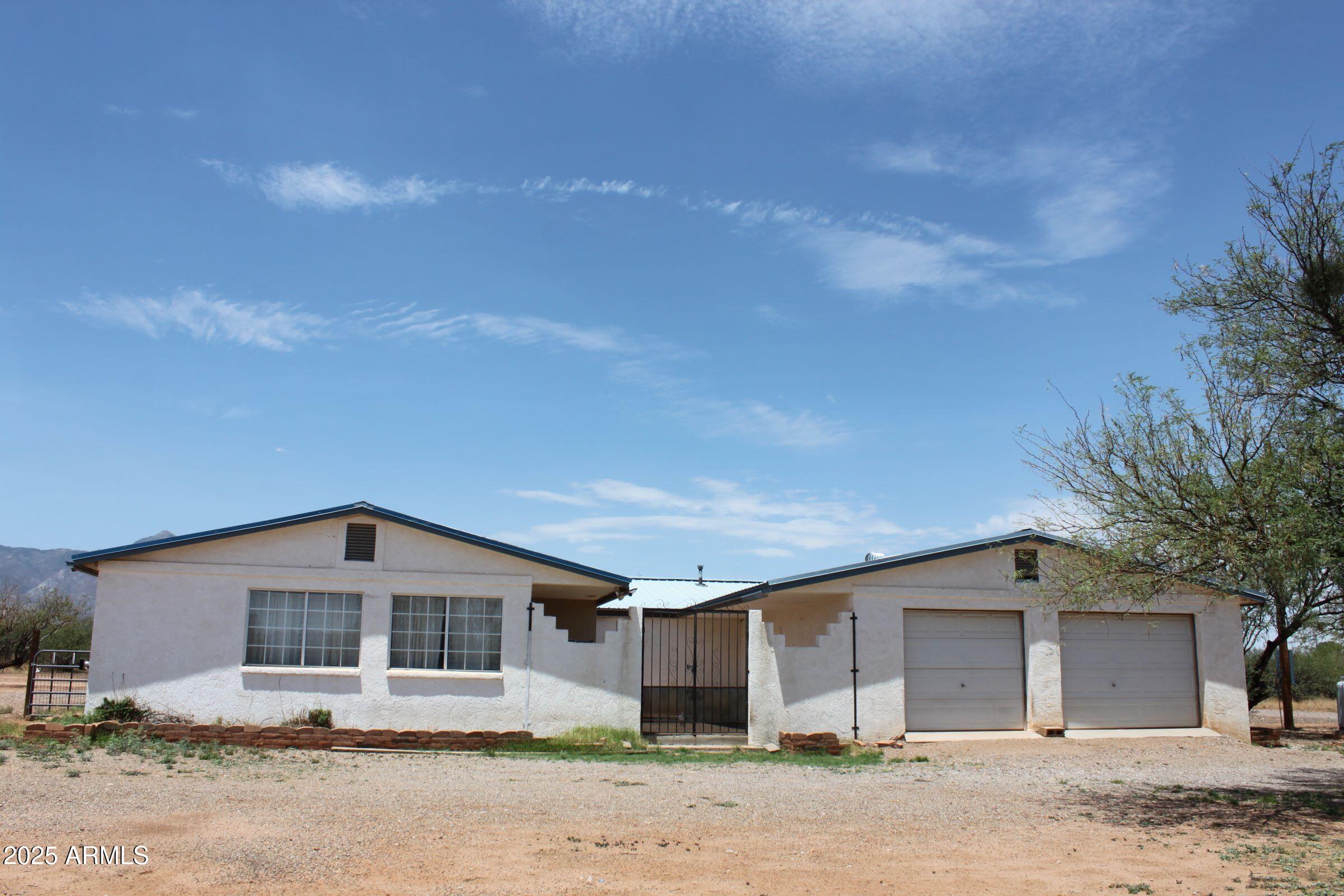 Stucco 4BR/2BA home on 4 acres...covered front entry with plant station. Site built AZ room offers two sliding doors that open onto a courtyard. Has a  the pellet stove.  Master BR has huge walk in closet..other 3 BR's have walk in closets as well.  One BR used as office.  Kitchen has tiled floor,  features an island w/dropped bar for casual dining, walk in pantry with shelves on three sides, like new French door 16 cu ft refrigerator..has the extra pantry drawer and bottom freezer  Formal dining area just off kitchen.  The living/great room has beautiful laminate floor, pellet stove.  Master suite is in this end of the home..offers huge walk in closet, en-suite bath w/soaking tub, dual sinks and step in shower, linen storage. Property offers a 2Car attached garage, shop/barn/storage shed, Fenced and cross fenced w/chain link fencing around the house.  Courtyard has a framed little room for kitties!  There is water in the courtyard, ideal for creating an outdoor kitchen. Shop/horse barn can be reconfigured to suit needs. Wood shed would make great workshop/office/craft room..she shed!  Just a short commute to Sierra Vista..Ft. Huachuca
