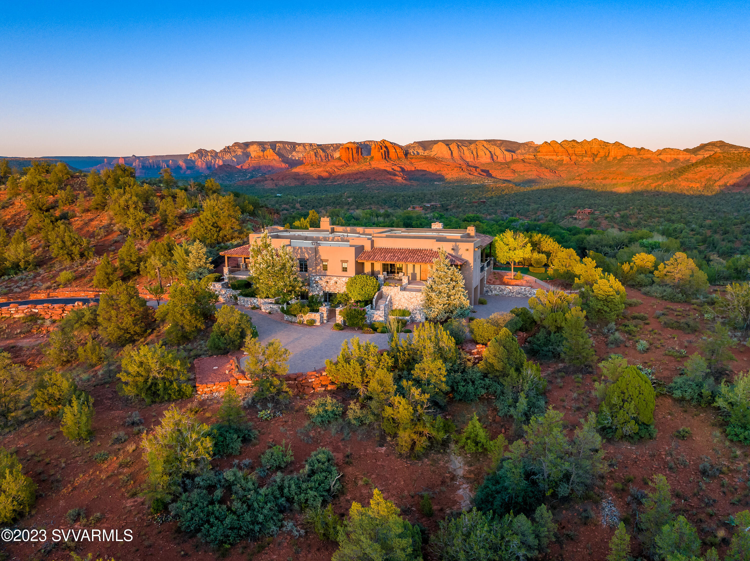 Exclusive Sedona Estate ideally sited on this high ridgeline lot overlooking the entire red slickrock valley bordering National Forest and Red Rock State Park.  Double gated for ultimate privacy, this home features a Southwestern design aesthetic throughout and boasts four season outdoor living with it's massive covered patio, outdoor kitchen, feature fireplace, and backyard pool. Main level living space is an ideal entertaining zone with an open floorplan gourmet kitchen, massive living room opening onto the exterior patio. Hike and explore the surrounding red rock mesas and buttes from the abutting underutilitized Turkey Tank trail system.  Remote workers and digital nomads- Gig speed Fiber internet connection at this location is the fastest in the entire area.