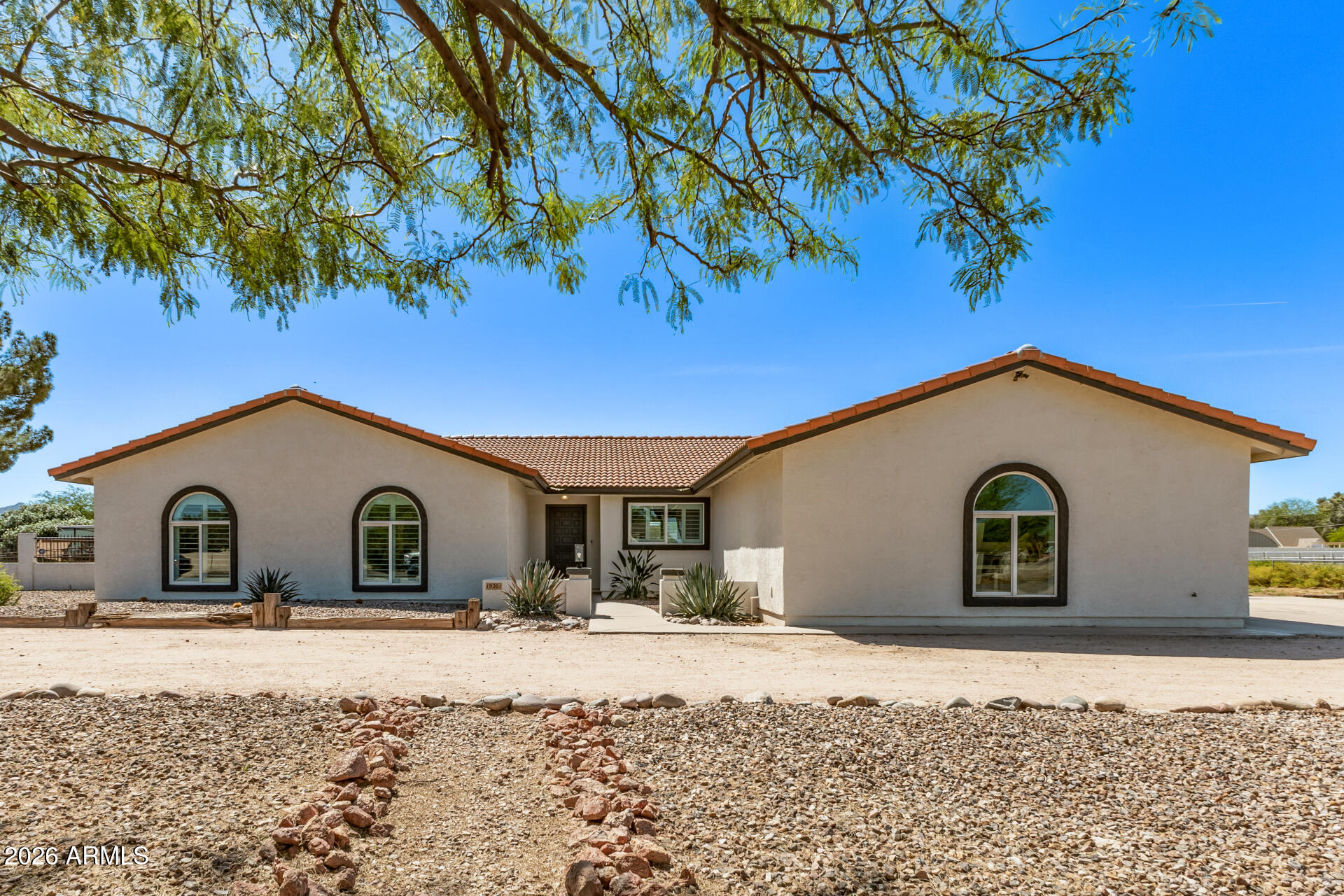 Experience refined desert living on over an acre in the desirable Ranchos Jardines area of Queen Creek. This beautifully remodeled single-level residence blends modern design with the freedom and space of acreage living without the restrictions of an HOA. Thoughtfully renovated from top to bottom, the home offers 4 bedrooms and 2 bathrooms in the main house. Inside, you'll find a bright and inviting interior featuring designer finishes, wide-plank flooring, and an open, comfortable layout ideal for both everyday living and entertaining. The stunning kitchen serves as the heart of the home, showcasing custom shaker cabinetry, quartz countertops,  stainless appliances, and an inviting breakfast bar, all designed with both beauty and functionality in mind. This home offers multiple areas for entertaining. The bathrooms have been beautifully appointed with a spa-like feel, featuring refined finishes and clean design lines that create a serene retreat to this contemporary design. Set on an expansive 1.06- corner acre lot, the property offers endless possibilities. With no neighbor to your west, enjoy wide-open space, mountain views, abundant parking, and room for recreational vehicles, toys, animals, or future enhancements. This property also features a covered livestock shelter, ideal for horses or small farm animals. A private detached studio or office provides additional flexibility, equipped with a half bath. Blending modern comfort with the privacy and freedom of acreage living, this exceptional property offers a rare opportunity to enjoy space, style, and versatility in one of the Southeast Valley's most desirable and fastest growing communities. An exceptional opportunity not to be missed.