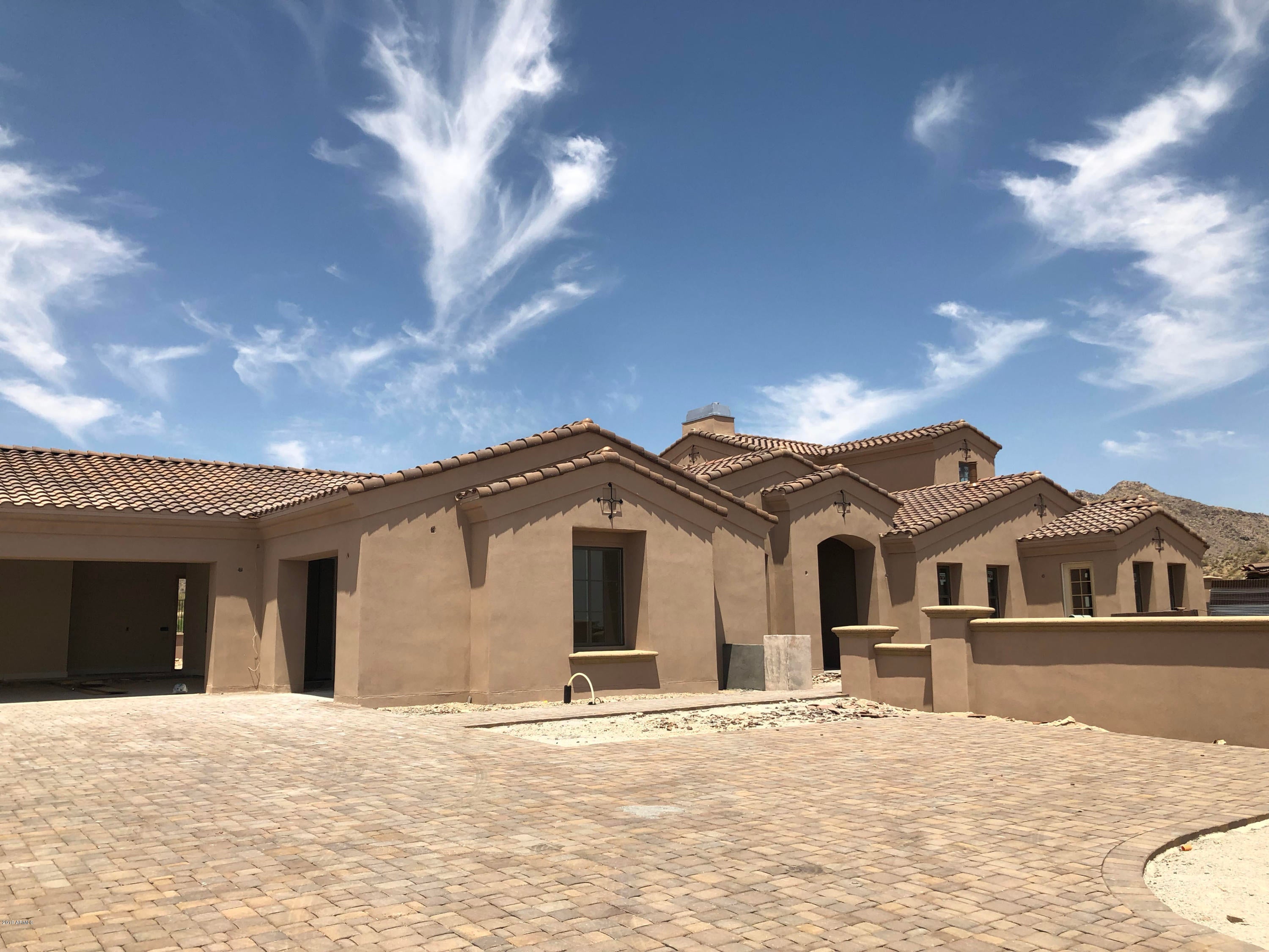 One of a kind new construction Spanish Colonial home for sale in the master planned community of Verrado. **Buyers still have opportunity to influence interior selections until July 1st, 2019.** Home features an open floor plan with 10' ceilings, 2 Master Suites and 2 additional bedrooms on the first floor in main residence. 802sf guest house with Kitchen, Living room, Bedroom and Laundry Hookup. Home features Central Vac, Fire Sprinklers, Prewired speakers and Security wiring all accompany the 4,658 livable sq ft. home with 7,120 sq under roof. Backyard to be finished with Heated Pebbletec Pool/Spa and an Outdoor BBQ area to enjoy golf course/mountain views. 3 Car garage w/ Epoxy Flooring and Large paver driveway. 2x6 construction and energy efficient features all t/o and so much more.