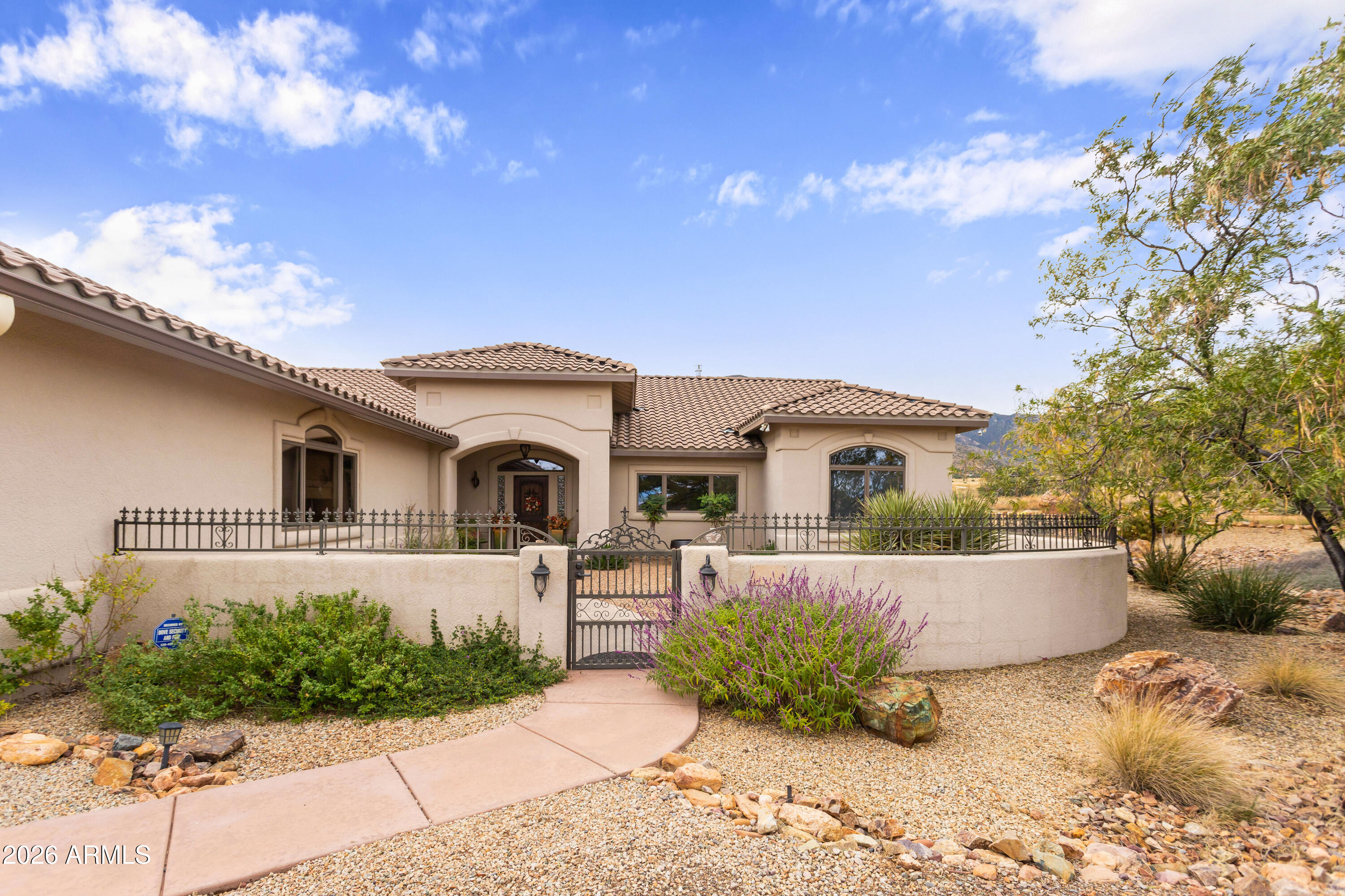 Gorgeous Walston custom home Wild Horse subdivision, perfectly situated on 3.5 acres with breathtaking 360° mountain views of the Huachuca, Mule, and San Jose ranges. Professional landscaping enhances the horseshoe driveway and private courtyards with custom iron gates. Inside, enjoy Anderson windows, vaulted ceilings, granite countertops, a breakfast bar, downdraft cooktop, and custom Alderwood cabinetry with roll-out shelves. The living room features a dramatic floor-to-ceiling stone propane fireplace. The fenced backyard offers privacy, custom desert landscaping, and expansive views. Both bathrooms include granite and Alderwood finishes; and the primary bath features a snail shower, Primary suite includes a versatile bonus room ideal for an office, gym, or retreat.