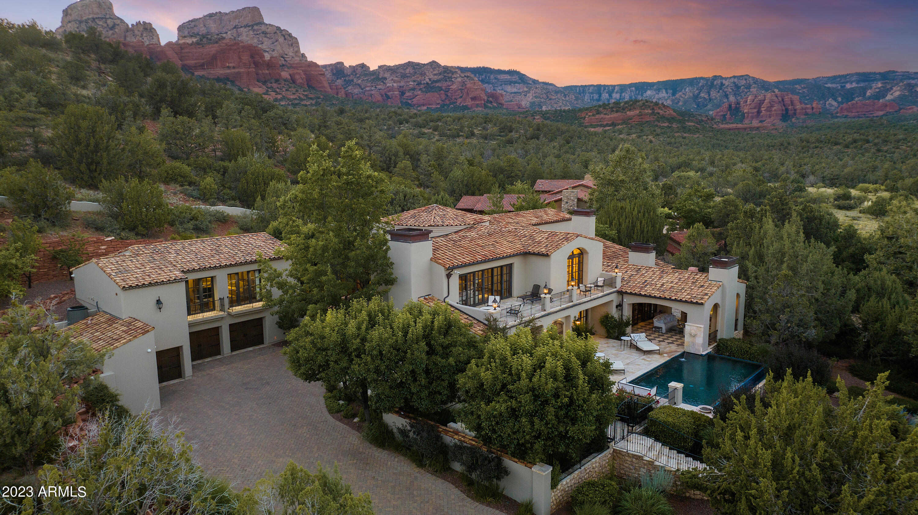 Indulge in luxury and tranquility backdropped by panoramic Red Rock Views at 130 Hidden Meadow Drive. An iconic Sedona Haven, ideally situated on an elevated 1.71-acre lot backing to National Forest and residing in the prestigious neighborhood of Solitude at Seven Canyons. Tucked behind the two gates, this European Villa-style estate offers a private and secluded oasis simply a step above the rest. Meticulously crafted by skilled artisans with recently added conveniences & lifestyle upgrades, the level of craftsmanship and attention to detail is evident throughout. Designed by award-winning architect Terry Kilbane with the interiors designed by Tim Hawkins and constructed by Phil Morris. Enter through the private courtyard to the grand foyer featuring... ...antique Spanish Andalusian tile floors and a circular staircase. Main level living areas include the decadent living room, the formal dining room with dual wine cellars, a recently remodeled gourmet kitchen and a family room all connected to the outdoor terrace with stunning views from every window. The sprawling primary suite is also located on the first level and features a fireplace, access to three private courtyards, custom hand-painted cabinetry, marble and onyx countertops, dual walk-in closets, a separate dressing room, two water closets, separate tub/shower and an outdoor spa. The remainder of the first level offers an executive office/den, laundry room, workout/storage room, and a breezeway to the well appointed attached guest house perched above the three car garage. Take the elevator upstairs where each space has access to a private balcony. You'll appreciate the split floor plan with two en-suite bedrooms, media room & library.    

Embracing the Sedona Lifestyle, this property creates a peaceful equilibrium with outdoor living just as elaborate as the home itself. Centered around the negative edge pool, newly added outdoor kitchen, and numerous private courtyards, covered patios and sundecks with water features and fountains that beckon you to enjoy Sedona's mild four seasons. Each space is beautifully landscaped and accentuates the panoramic Red Rocks Views. 

Interior showcases custom doors and windows, French chandeliers, antique limestone fireplaces, Austrian hand-forged metal work, custom cabinetry throughout, and beautiful Spanish marble and French Oak floors. Additional amenities include Butler's pantry, technology conveniences from WiredUp, automatic draperies in the Media Room, radiant in-floor heating, an elevator, and a half bath on each level. See the list of features attached. 

Every aspect of this exclusive Seven Canyons community embodies sophistication. Offering privileges to golf, clubhouse, restaurant, fitness center, pool, and access to Enchantment Resort. Only 5 miles to all other Sedona services. Book a private tour to experience the grandeur of this unique estate and luxury lifestyle in a one-of-a-kind setting.