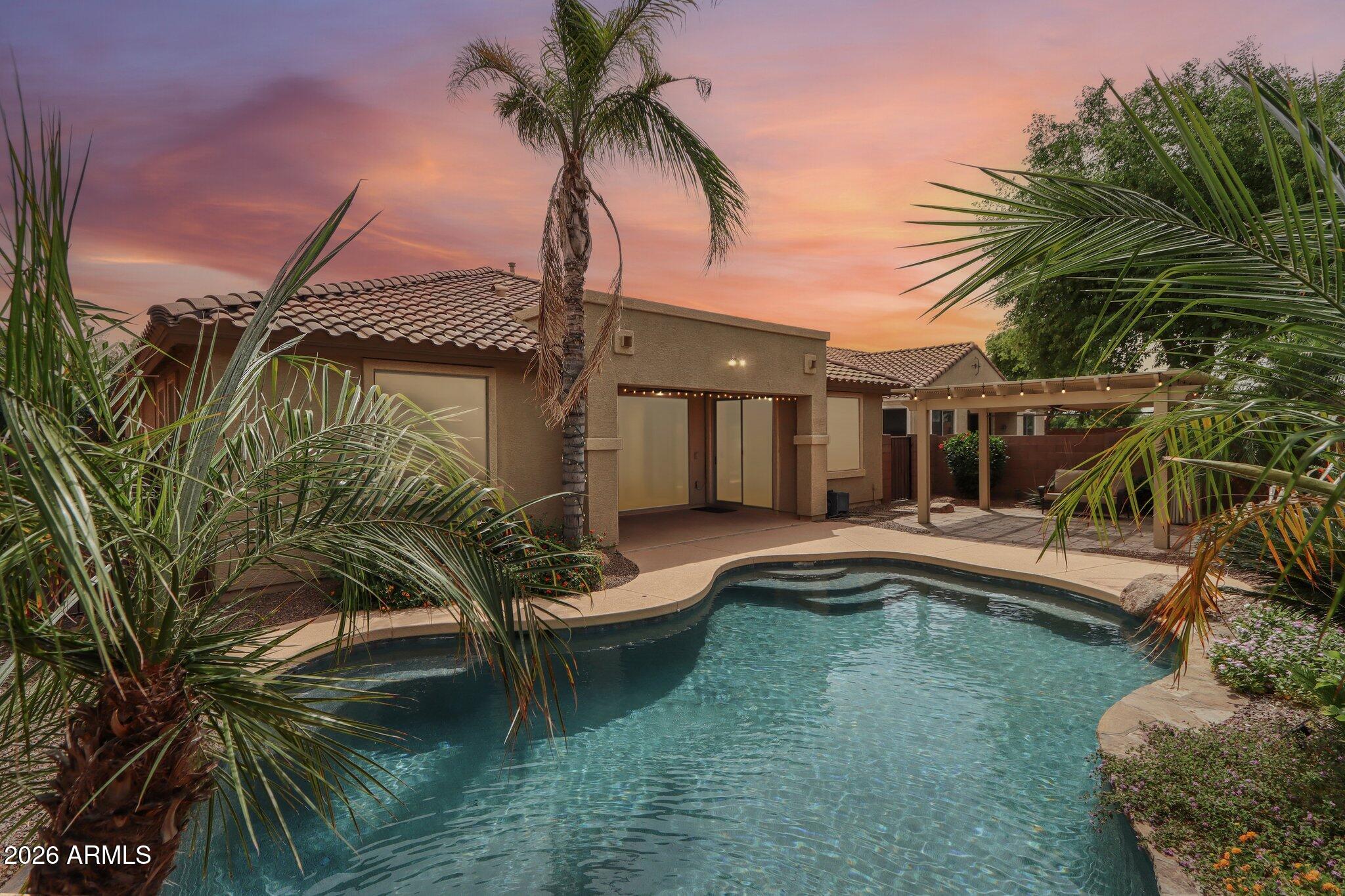 Welcome to your private Gilbert oasis in Eagle Glen II! This stunning 4BR + Den home has been reimagined for the ultimate AZ lifestyle. The centerpiece is a brand-new accordion-style glass wall that seamlessly blends the interior with a resort-quality backyard. Step out to your sparkling pool with a premium N/S exposure and rare privacy, backing to a peaceful open area with no neighbors behind.

Go green and save big with fully owned solar panels, drastically reducing utility costs. The floor plan features 4 bedrooms, 2.5 baths, a versatile den, and a 2-car garage with an RV gate. Located steps from lush parks and miles of biking/walking paths, this Standard Pacific home offers the perfect mix of luxury and efficiency. Don't miss this move-in-ready gem in a premier community!