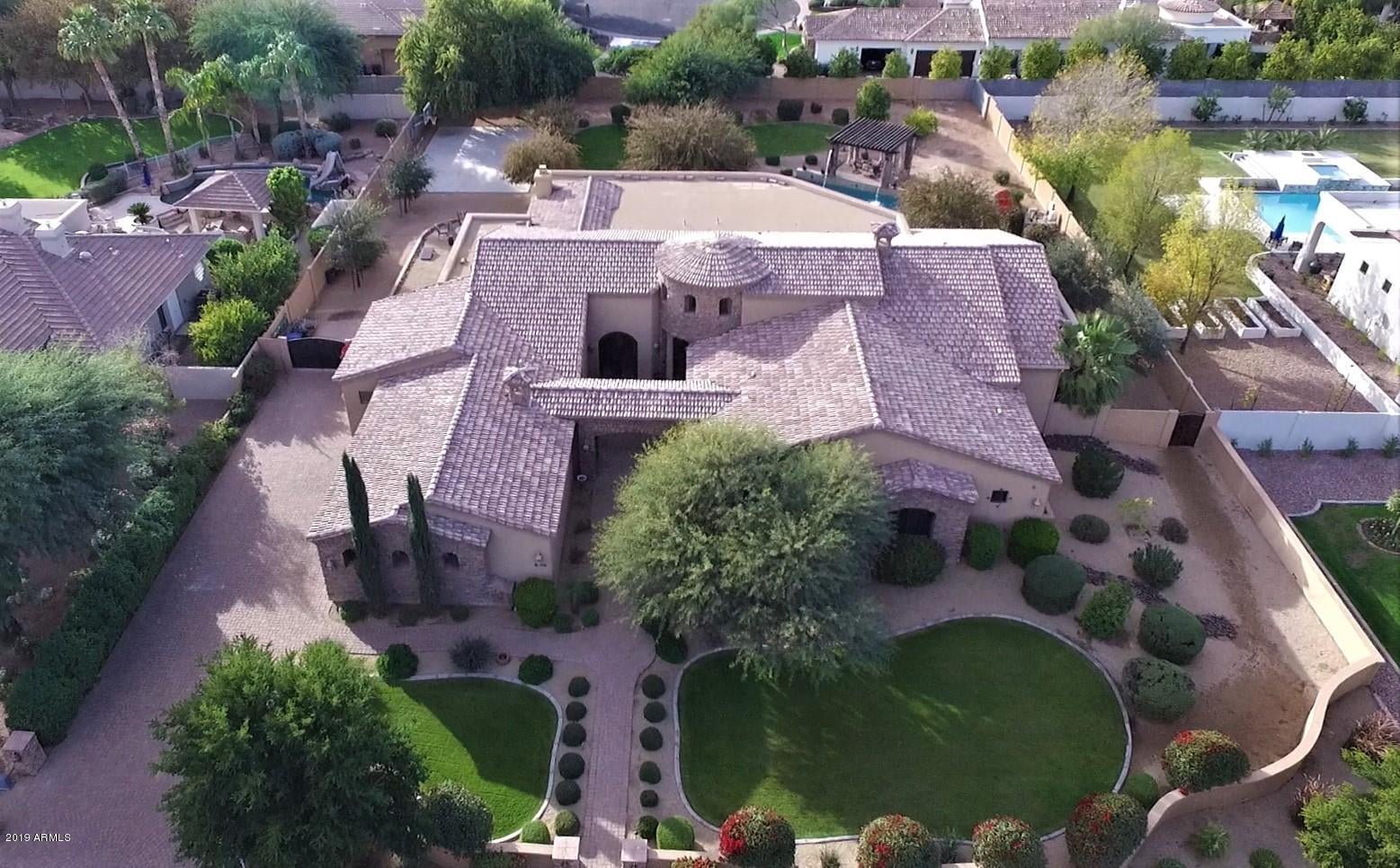 BASEMENT HOME!  Original owner constructed this extraordinary 5 Bedroom 4.5 Bathroom CUSTOM gem in the highly sought after Circle G at Riggs Homestead neighborhood. The main level includes 3 beds, 3 baths and a powder room! The gourmet kitchen features an oversized island, double ovens, custom cabinetry, walk-in pantry, and a sub-zero fridge that can accommodate the largest of families. You will be blown away by the formal living room, formal dining room, and den that includes a separate double iron door entrance from the courtyard. Other bonus space includes a massive billiard room, wine cellar, and 2 bars. The Master Suite is breathtaking with His/Hers vanities, oversized tub and dual head shower, and master closet bigger than most bedrooms. It also has a sitting room with double iron doors leading to the backyard! The BASEMENT includes 2 beds and 1 bath with a kitchenette as well as a bonus room that can be used as a gym, media room, or storage. 

The HUGE backyard has something for everyone! Watch the sunset on the massive patio offering covered and uncovered sitting areas, perfect for entertaining. The resort-style yard also includes a half court basketball court, outdoor kitchen and BBQ, gas fire pit, and 40,000 gallon pebble-sheen pool and spa including a pergola and water feature. Mature landscape includes mesquite and citrus trees as well as plenty of grass for the kids. The oversized 4 car garage and RV gate make for plenty of parking space for cars, trucks and toys. Other features include coffered ceilings, wood shutters, solid wood beams, custom copper sinks, granite countertops and custom travertine tile throughout. Conveniently located close to great schools, restaurants & shopping. This is one of the most prestigious homes in all of Chandler!