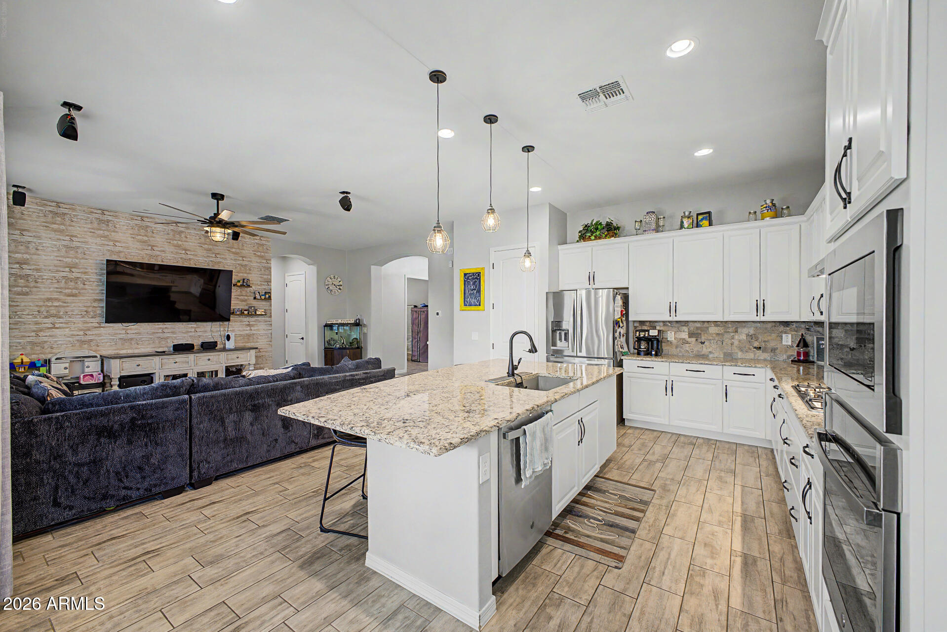 Beautifully upgraded , HUGE single-story home featuring 3 bedrooms plus a versatile den, perfect for a home office or flex space. This spacious layout includes a 3-car garage and an open-concept design ideal for everyday living and entertaining. The gourmet kitchen shines with high-end finishes, while wood-look tile flooring adds style and durability throughout. Enjoy a fully landscaped backyard complete with an outdoor fireplace,  built-in BBQ and gas line, perfect for hosting. Located in a vibrant, active community with HOA covering trash and sewer for added convenience.