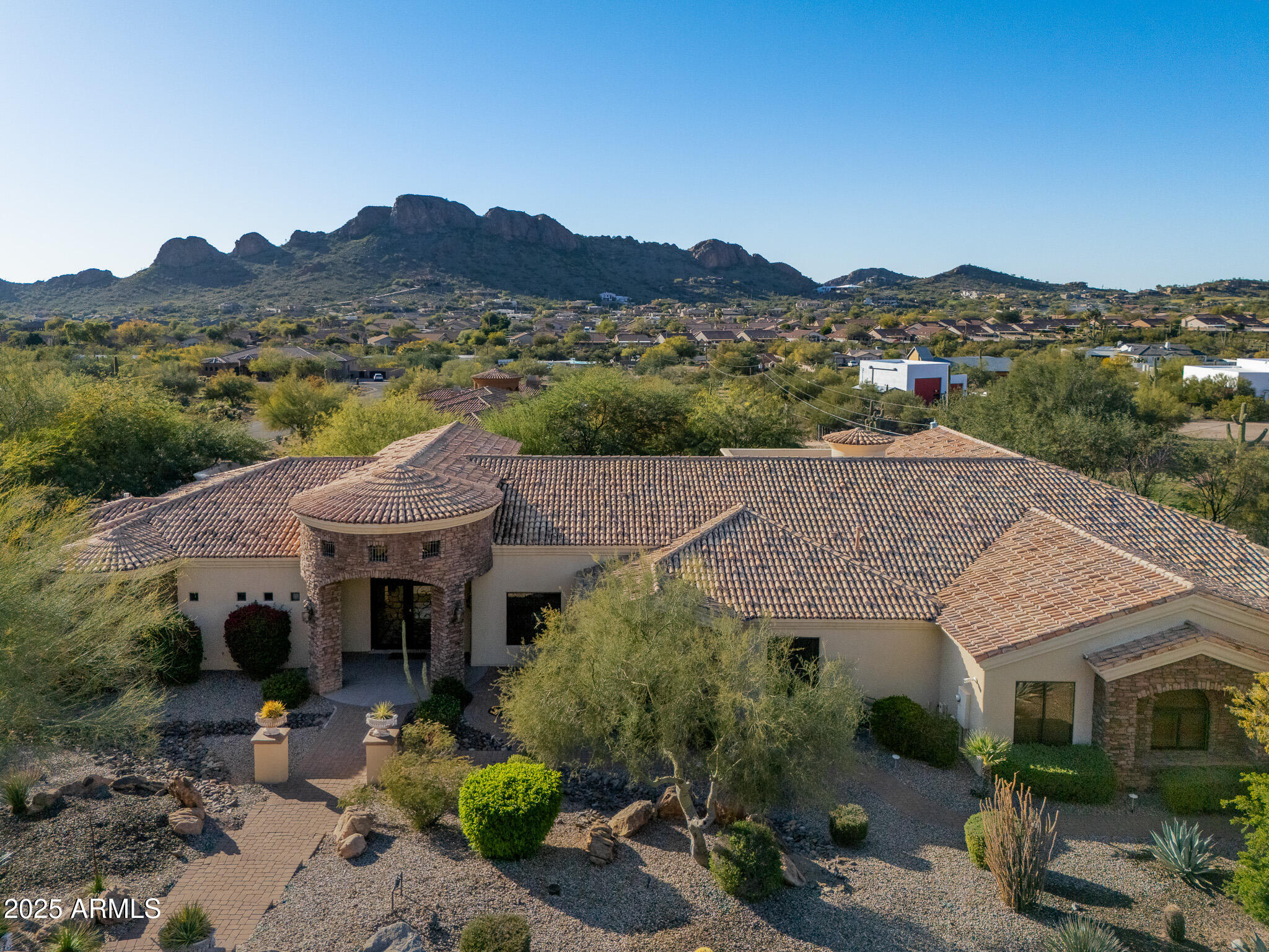 Exceptional 4-bedroom + den, 5-bath home located in a sought-after gated community with breathtaking views of the Superstition Mountains. Beautifully landscaped and expansive windows highlight stunning views throughout the home. The gourmet kitchen features knotty alder cabinetry, granite countertops, a six-burner natural gas cooktop, double ovens, walk-in pantry, and opens to a spacious family room—perfect for entertaining. Separate living and dining rooms add flexibility and elegance. The large primary suite offers a private retreat with a newly added steam shower, while 3 of the 4 bedrooms include en-suite bathrooms. The entire home is equipped with an integrated sound system and security cameras. This six-car garage with RV gate is every car enthusiasts dream. The backyard is a true showstopper with water features, fire features, lighting, and low-maintenance artificial turf, ideal for year-round enjoyment!