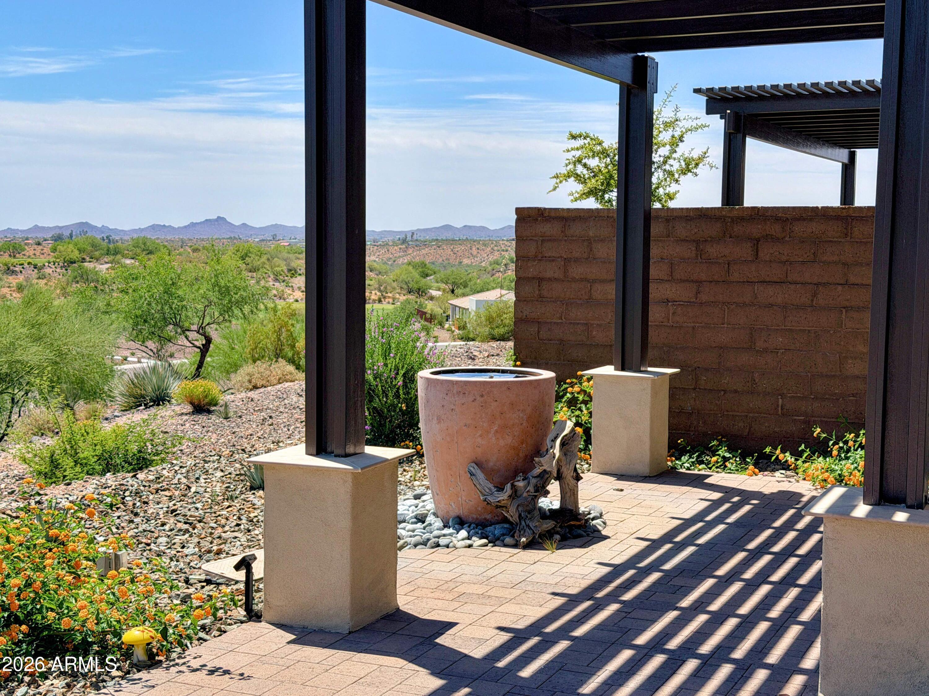 Amazing unobstructed vistas of the golf course and Vulture Peak from extended patio, pergola, fan and two relaxing water fountains. Over $90,000 of upgrades! (See MLS Documents Tab) $80,000 lot premium. Seller purchased property for $599,026!  Fantastic floor plan includes a separate OFFICE. Kitchen, upgraded granite, stainless Steel appliances. Dining Room has shiplap custom wall, custom bench, custom light fixture. Home is in Resort Area, where HOA fees pays for the landscape maintenance once per month, irrigation repairs, irrigation to plants and trees, granite replenishment, and painting of the duplex.