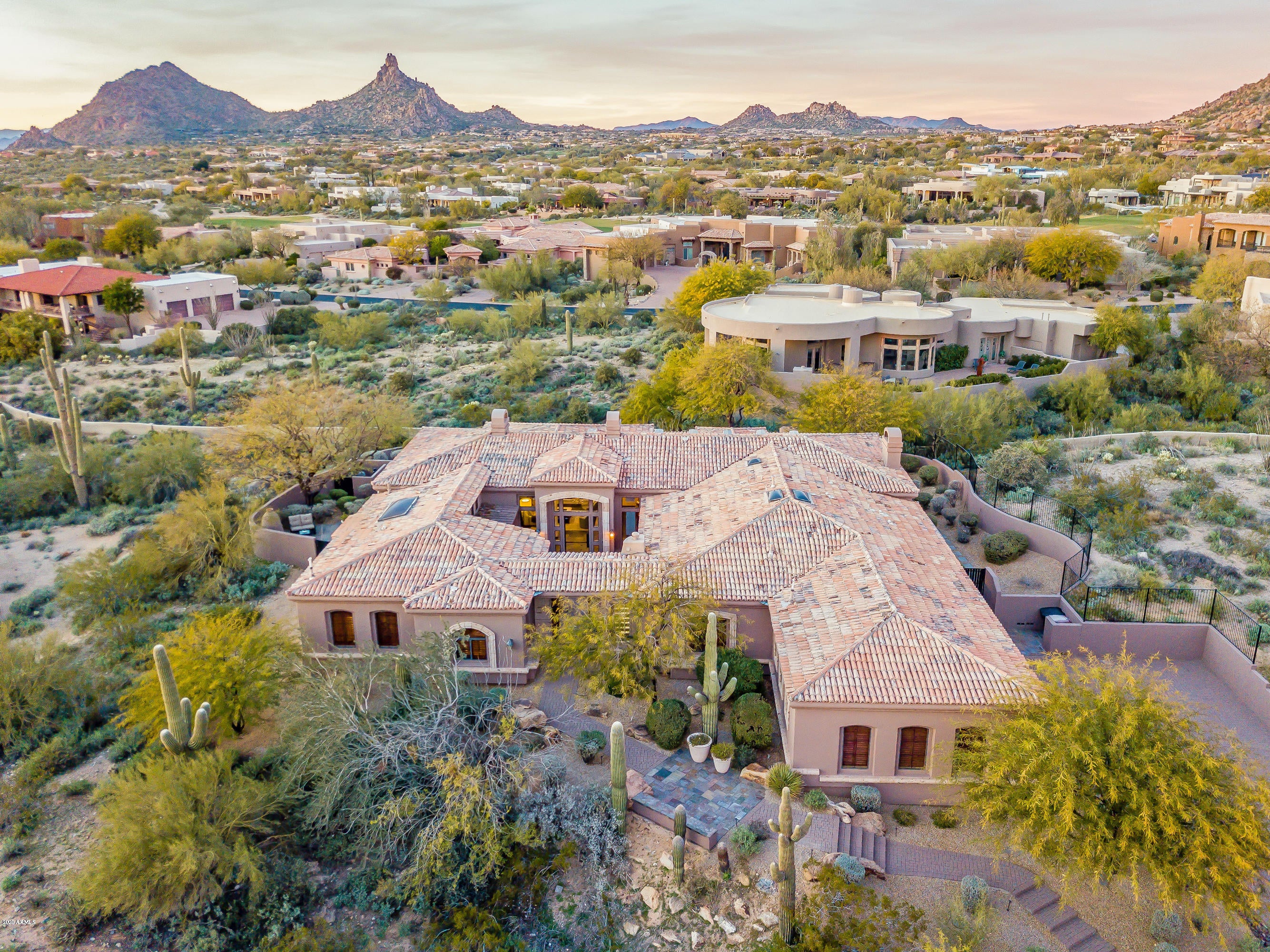 Sunrise to sunset, this property's views of Pinnacle Peak and the Sonoran Desert immediately command attention upon entering this classic residence featuring 4 bedrooms, a library and flex room inside the gated community of Sonoran Highlands. The interior has been tastefully updated with transitional details throughout the functional split floorplan, while the exterior features the most charming outdoor living spaces scattered from the welcoming front courtyard to private master bedroom patio to the expansive backyard perfectly designed for entertaining with a negative edge pool, free-formed spa, outdoor kitchen and 3 outdoor fireplaces. New lighting, slate and granite floors, stacked stone accent walls, built-ins, 3 interior fireplaces, and all guest rooms feature en-suite bathrooms. Guests will enjoy total privacy in the casita with separate entry. Kitchen is well equipped with Viking appliances including a 6 burner gas cooktop, 2 dishwashers, 2 beverage drawers, large center island, and 144 bottle climate controlled wine cellar. Oversized 3 car garage loaded with storage, epoxy floors and a workbench. This residence truly feels like an escape from it all while less than 15 minutes from nearby golf, hiking, shopping and dining. Please be sure to view the video attached to the listing - it will not disappoint. Furnishings available by separate bill of sale.