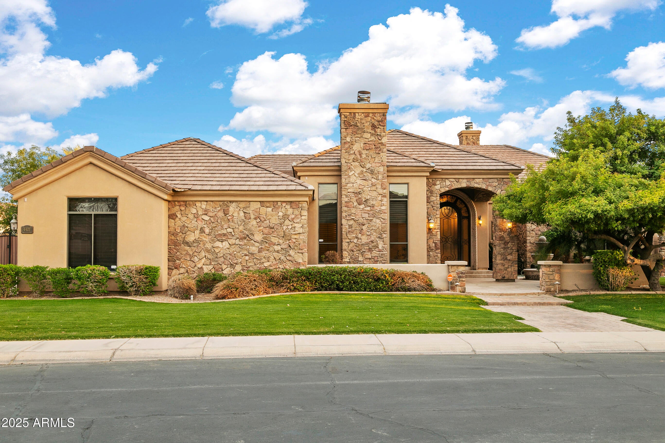 Welcome to your private retreat! This 4,000+ s/f home on an 18,000+ s/f lot in the exclusive Vesaro gated community offers 4 bedrooms, 3.5 baths. The stucco and stone exterior, travertine courtyard, lush lawn, and 4-car garage with epoxy floors exude curb appeal. Inside, the open floor plan includes a grand foyer, a living room with a gas fireplace, and a chef's kitchen with granite counters, Sub-Zero appliances, and a wine fridge. The primary suite boasts vaulted ceilings, a spa-like bath, and backyard access. The west wing features 3 bedrooms, a bonus room, and private patios. The backyard is perfect for entertaining with a travertine patio, pool, spa, fire pit, sport court, putting green, and built-in BBQ. Nestled on a peaceful street, this home is a  gem ready for your personal stamp!