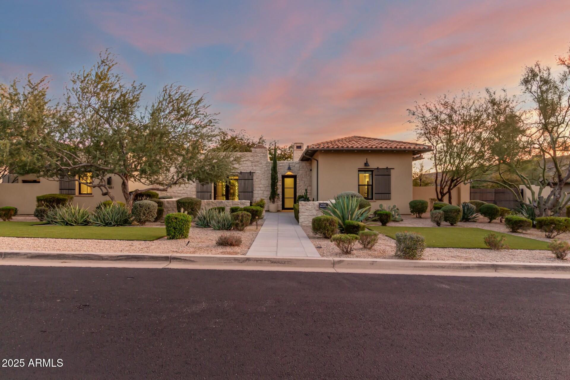 This amazing, gated community brings together vibrant, and award-winning contemporary design with seamless indoor-outdoor living. Explore the stunning desert surroundings just minutes from north Scottsdale's finest dining and shopping destinations. This incredible contemporary home offers timeless indoor-outdoor appeal, all in a highly desirable location, with beautiful city & mountain views. Enter the porte-cochere and bring you and your guests into this inviting and unique courtyard, with a massive stone gas fireplace, lush landscaping, 10' long granite counter bar, with bi-folding Andersen steel & glass windows that open to the interior kitchen for an amazing outdoor entertainment at its best. Imagine yourself relaxing or entertaining guests in this gorgeous courtyard, with your favorite music playing....Pretty cool experience. Stone, steel, glass, and stucco complement the impressive single level luxury builder model home. From the courtyard, enter the keyless entry into this 6491 Square foot amazing residence. Nothing was spared in this home, with the best of high end luxury at your convenience, from Wolf, Subzero, 400 bottle+ temp controlled wine room, gorgeous cabinetry, 17 foot massive granite waterfall island in the kitchen, 4 floor to ceiling stone gas fireplaces, very impressive wood ceiling beams, three main house interior bedrooms, with in suite bathrooms, and an amazing office from its impressive entrance to its wall wood walls, that features the 400 bottle+ glass wine room and an in suite bathroom. This home is truly a dream, bring the indoors to outdoors with 3 sets of opening glass wall doors, from the dining room, the great room, and the kitchen. What an amazing feel! The master suite is what dreams are made of. Two beautiful steel/glass French doors open to the courtyard on one side and the others open to a large outdoor gas fire pit. High ceilings, wall features, and one of 4 massive floor-to-ceiling stone gas fireplaces feels this suite with warmth. A beverage-coffee -refrigerator center greets you as you enter the master bath featuring floor-to-ceiling stone walls, complete with a gorgeous soaking tub, a huge walk-in shower, his & hers dressing rooms, and a wall of glass stacked doors with an outdoor shower for those days when you dare to bare it all. The laundry room features dual stacked washer & dryers, beautiful cabinetry, and a gorgeous large stone top island. The large flex/media room, just down the expansive hallway has beautiful multiple floor-to-ceiling wall features, great for the kids the hangout. In the pantry you'll find plenty of space and an additional 36" subzero refrigerator. Wow!, resort living at its finest in this amazing entertaining backyard, with another floor-to-ceiling stone gas fireplace surrounded by gorgeous outdoor living, complete with a stone wall pool with water features, a built-in wolf grill and refrigerator area, luscious and manicured landscaping, a separate stone spa with water feature overlooking the remarkable city lights & mountain views. What a great place to entertain. Let's not forget the nearly 866sf guest house with all its luxury features from the great room's with its entertainment wall feature, beautiful kitchenette, large bedroom, and gorgeous bathroom, and what would a guest house be without its own full size stacked washer & dryer. Great place for your guests. Lastly the automatic wood & steel privacy gates meet you as you pull up the long driveway to your 2/2 car garages (one garage attached to the home & one garage detached) with an amazing set of automatic barn doors that open to your resort backyard. Detached garage is also air conditioned. Great feature for your cars!