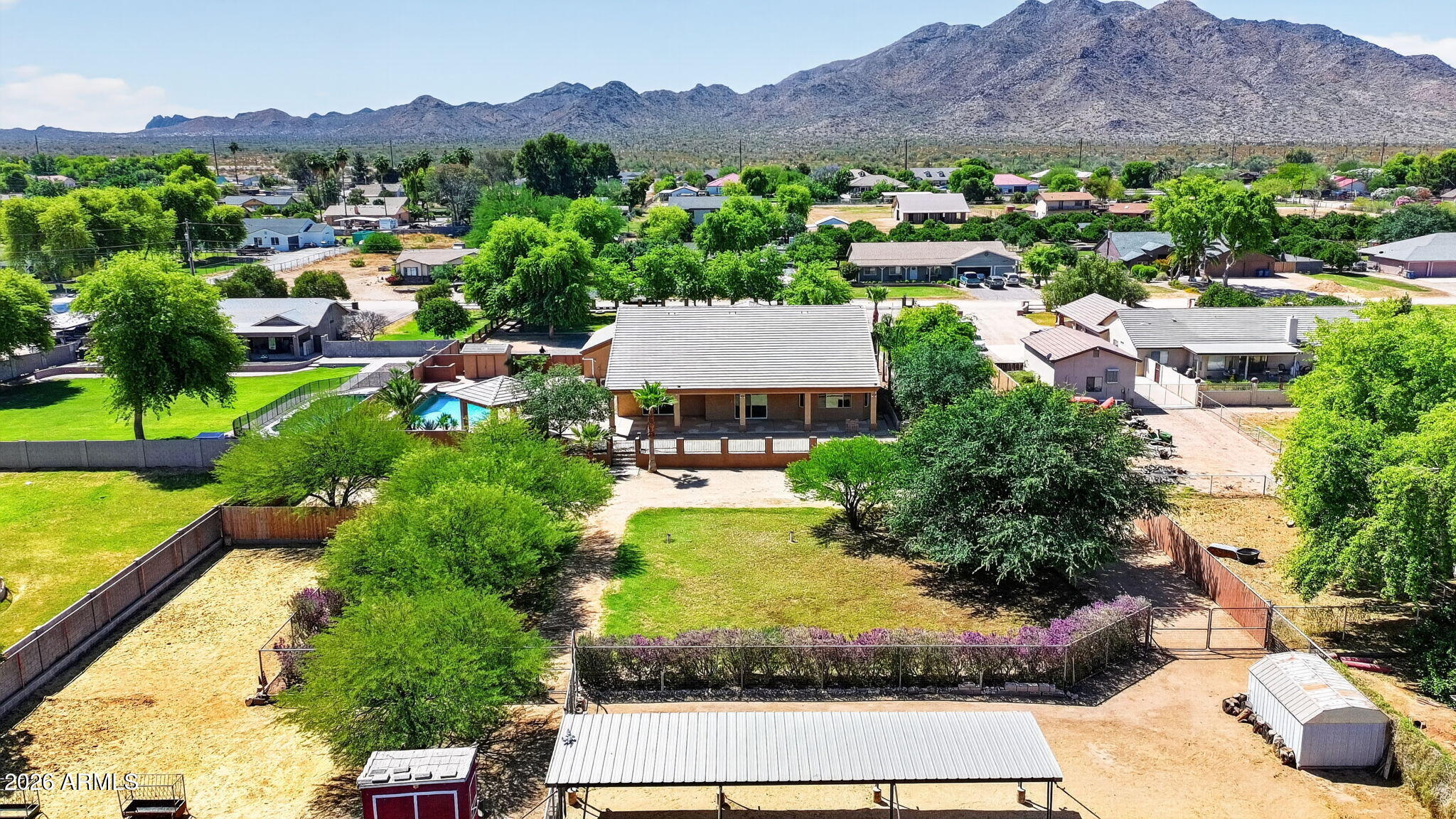 This exceptional home and property offer an impressive combination of quality, functionality, and space, situated on a remarkable 60,978 sq ft lot that provides privacy and versatility rarely found. Enjoy a rare balance of a quiet, rural atmosphere with expansive space and mountain views, all while remaining just a short drive from nearby restaurants, shopping, and everyday conveniences. Built with 2x6 custom construction and meticulous attention to detail, the thoughtfully designed floor plan features five generously sized bedrooms, three bathrooms, and two full primary suites. Interior highlights include a formal den and dining room, a built-in entertainment center, rich dark cherry cabinetry, Corian countertops, marble finishes, a custom snail shower, coffered ceilings ranging from 10 to 14 feet, and wood window sills. The primary suite is well-appointed with a spacious walk-in closet, marble tub, and custom shower. The expansive four-car garage includes 8-foot insulated doors, extensive built-in cabinetry, and a large workbench, ideal for storage and functionality. Outdoor amenities are equally impressive, featuring a Pebble Tec pool, gazebo area, and large covered patios designed for entertaining. The horse property is equipped with three stalls, multiple fenced areas, and irrigation in both the front and back yards. Additional features include RV parking with dual gates, a 400-amp electrical panel, dual water heaters, a recirculating pump, and variable-speed AC units--showcasing the home's quality construction and thoughtful upgrades throughout.