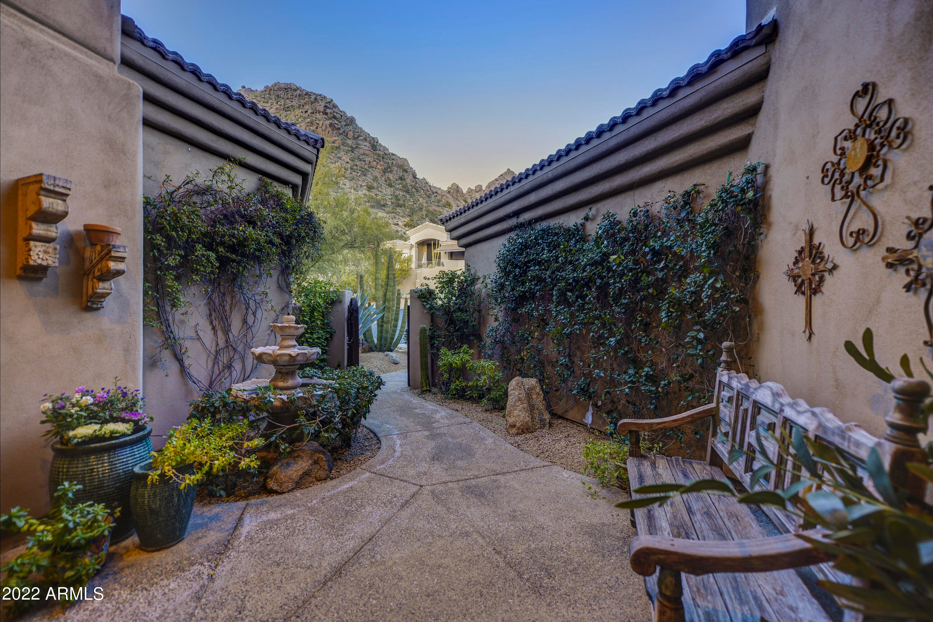 Enjoy mountain, sunset and city light views in this beautiful hillside home, located in the gated community of Whispering Ridge at Troon Village. 

Nestled into the hillside of picturesque Troon Mountain, this home is perfect as a ''lock and leave'' vacation home or for full-time living. Furnishings are available, making this an easy ''turn-key'' opportunity.

The charming front courtyard--artfully and lushly landscaped--sets the stage for wanting to discover all this home offers. Designer touches are seen throughout.  Scottsdale's well-known Wiseman and Gale Interior Designers handled the original renovation details of the home, garden and outdoor areas. The character and details of the home brought it to the attention of Phoenix Home and Garden, leading to the home being featured in one of the magazine's earlier issues.  

Outstanding details in the home include a sophisticated lighting system, beautiful wood floors in all the main rooms, designer wall-treatments, a stone fronted fireplace in the family room, custom wood shutters and draperies, mechanical sun- shades, top of the line stainless steel kitchen appliances (SubZero, Viking, Bosch), an abundance of cabinets in the kitchen, a steam shower in the master bath, along with a Kohler soaking tub and a very large walk-in master closet.  

Whatever your lifestyle, this 2,920 SF home with 3 bedrooms and 3 bathrooms allows for easy living.  The great room--highlighted by a massive window that brings in natural light and the patio and sunset views--and the intimate formal dining area offer the perfect casually elegant atmosphere for entertaining.

The best words to describe the heart of the home--the eat-in kitchen that opens directly to the family room, highlighted by the stone stacked fireplace-- is intimate, cozy and relaxed.  Sliding patio doors give direct access to the pool, spa and outdoor entertainment areas.

From the south facing outdoor area with its flagstone patio and decking, the pebble tec pool, spa, waterfall feature and a built-in BBQ, you can enjoy gorgeous mountain, sunset and city light views and dining al fresco in front of the outdoor fireplace.

An oversized master suite also provides direct access to the back patio, pool and spa. While both secondary bedrooms are ensuite, one is a perfect junior master bedroom and the the third is currently used as a den/office. 

In addition to residents enjoying the community pool at Whispering Ridge, there is also quick access to hiking and biking trails in the Sonoran Desert Preserve, with Pinnacle Peak, Tom's Thumb and Brown's Ranch Trailhead being very close by.  Not to be forgotten are area lakes for fishing and boating.

Located a half mile away is the Troon Golf and Country Club, offering golf and social memberships through an application process.  In addition, many of Arizona's top golf courses, such as Scottsdale National Golf Club, Troon North, Estancia, The Boulders, DC Ranch Country Club and Silverleaf Country Club are just an 8 to 20 minute drive away. Wonderful casual and fine dining restaurants, all types of shopping, area schools and hospitals, including the Mayo Clinic, are also nearby. 

Looking for more? Scottsdale is known for its art and culture and offers an incredible mix of museums, shopping, restaurants, galleries and nightlife, along with a wide range of performing arts and special events such as baseball's spring training, Barrett-Jackson car auction, the Arabian horse show and the Waste Management Phoenix Open Golf Tournament.

Furnishings are available by separate bill of sale, making this home an easy "turn-key" opportunity.