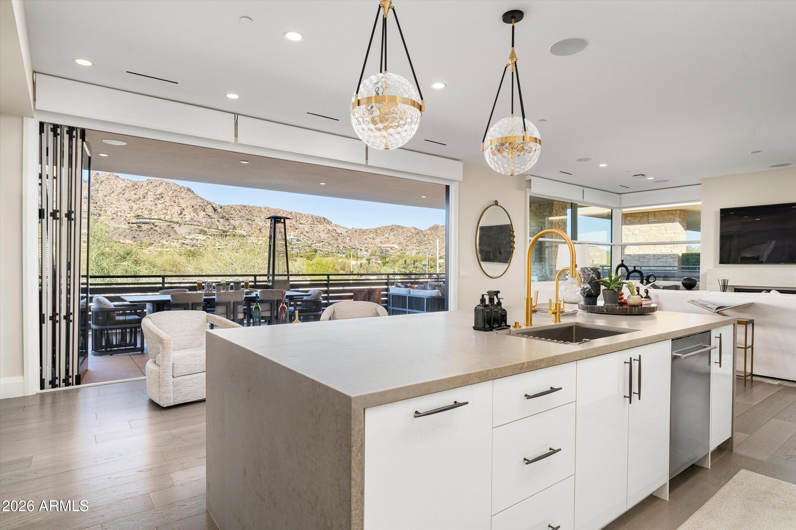 Welcome to this luxury villa located within the exclusive Mountain Shadows Resort community in Paradise Valley. Inside, soaring 10-foot ceilings and rich wood flooring create a refined yet warm atmosphere throughout. The great room is designed for seamless indoor/outdoor living, featuring expansive 9-foot bi-fold doors that open to the outdoors and fill the space with natural light. Both indoor and outdoor gas fireplaces add comfort and ambiance, perfect for entertaining or relaxing year-round. 
The kitchen is a true showpiece, outfitted with premium designer finishes and top-tier appliances, including a Wolf dual-fuel range, convection microwave, steam oven, a 48-inch Sub-Zero refrigerator, Sub-Zero wine tower, Asko dishwasher, and Zephyr hood. Quartz countertops with a waterfall edge complete the sleek, modern aesthetic.
This villa also features Savant home automation, an in-home elevator, motorized shades, and custom wood shutters for ease and convenience. The attached two-car garage includes an epoxy floor, and the home is Energy Star rated for efficiency.
Residents enjoy the peace of mind of a 24-hour guard-gated community, along with access to Mountain Shadows Resort and its full suite of amenities, including concierge services, a 4,500-square-foot fitness center with group classes included, a heated resort-style pool, golf, the Sanctuary Spa, tennis, and more.