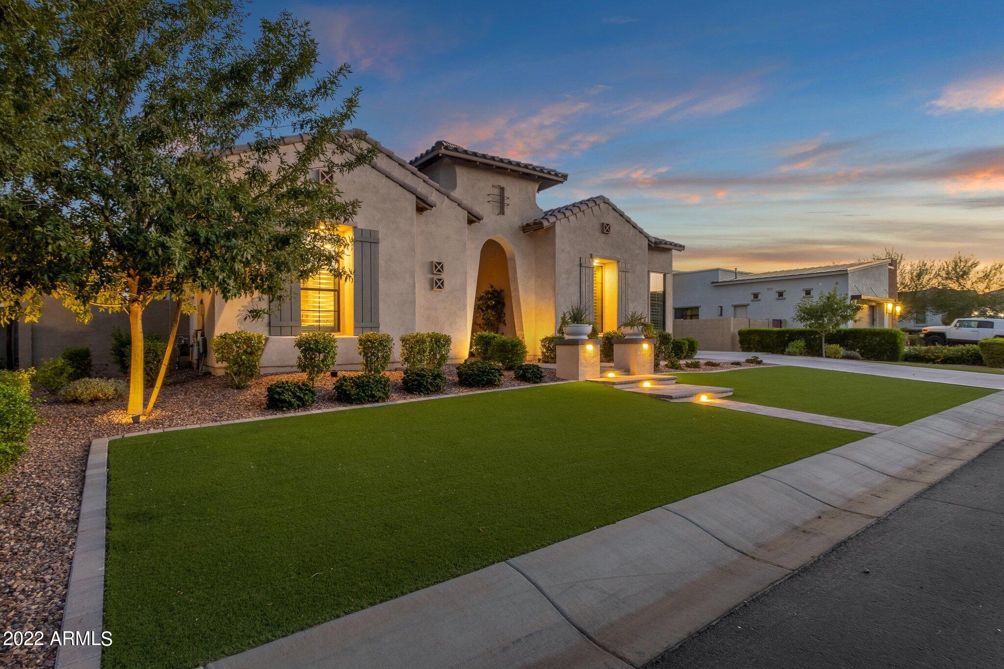 Magnificent Toll Brothers home in Gilbert's premier gated community, Calliandra Estates.  The 3847 square foot single level home features a total of 5 bedrooms, 3.5 bathrooms, and an office/den and is situated on a 13,050 square foot north/south facing lot.  One of these bedrooms and full baths can be found in the guest quarters with private entry where you guests will certainly feel welcome.  You will enter through the private enclosed courtyard with custom built fireplace and find yourself admiring the open concept floorplan that overlooks a gorgeous backyard.  The  kitchen is every entertainer's dream and features top of the line appliances to include, a built-in Kitchen Aid under cabinet ice maker, a Gas range with vent hood , a Water Works pot filler, an abundance of crisp white full-overlay cabinets paired perfectly with this bold blue oversized island with integrated cabinetry and comfortable seating for four.  Overhead you will admire the spectacular Copper pendant lighting.  You will also find a dedicated pantry.  Let's talk about this eat-in kitchen with dreamy blue wallpaper!  Plenty of space here for a sprawling table for casual dining or holiday feasts.  The kitchen opens up to the great room which features soaring 12 ft ceilings, a custom built gas fireplace and marble surround, and plenty of natural lighting brought in by the oversize multi-slide windows.  The owner's suite is located a separate wing of the home and is fit for a Queen.  The bathroom rivals any spa in town featuring dual separate vanities with marble countertops, a soaking tub, and large custom tile shower with glass enclosure. The huge walk-in closet is perfectly designed for organization and conveniently flows into the laundry room complete with sink!  As you make your way to the secondary bedrooms you will find a perfect office that opens to the front courtyard and is tucked behind a custom built barn door. The three secondary bedrooms are all generous in size and have walk-in closets.  Two of the bedrooms share a Jack and Jill bath.  You will also find a powder room ideal for guests.  As mentioned earlier your out of town visitors have a special retreat in their private Guest Quarter with private entry.  This space is cozy and spacious and has a full bath.  Arizonans love to have  a backyard which an extension of living space and this backyard has just that!  Whether relaxing under the covered patio gathered around the TV,  floating in this custom built pool designed perfectly with a water feature and a large baja step, practicing your swing on the putting green, or cooking on the built-in grill under the Pergola... the list goes on and on!  Other features include Plantation Shutters throughout,  surround sound, security system, low maintenance artificial turf in the front and back yard, custom light fixtures to include Fanimation ceiling fans, custom plumbing fixtures and faucets throughout, Over-height 3 Car Garage with Epoxy flooring,  an energy tight home. Over 300k in upgrades with no detail overlooked!  Calliandra Estates is an exclusive gated community with a lovely and inviting entrance, green spaces and tot lots for the kiddos, a cozy gathering space with seating for the residents and guests, a private clubhouse to host events, and so much more.  Top ranked schools and easy access to freeways, shopping, restaurants, and schools. Homes of this caliber don't come up often so hurry before you miss out.