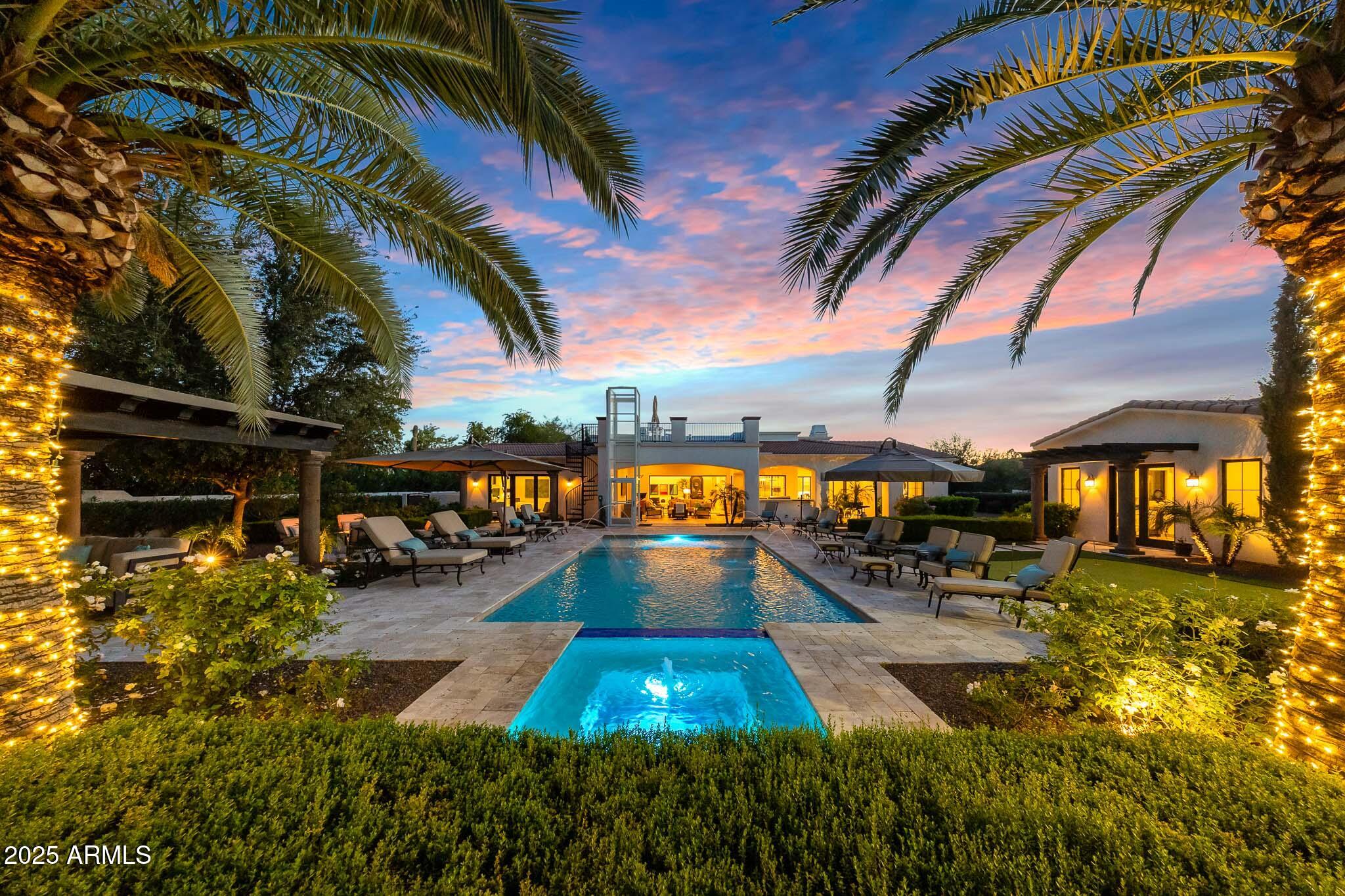 Home comes fully furnished!! Experience exceptional luxury in this exquisite Paradise Valley custom home, ideally positioned in the heart of one of Arizona's most coveted neighborhoods. Situated within walking distance to Gainey Ranch and moments from Camelback Golf Club, this residence offers stunning mountain views and an unmatched combination of craftsmanship, design, and resort-style amenities. Inside, the home features soaring 14-ft ceilings, vintage white oak flooring, and imported hand-carved limestone fireplaces. Automated sliding pocket doors create seamless indoor/outdoor living, while the chef's kitchen showcases marble and quartz surfaces, Sub-Zero and Wolf appliances, dual Miele dishwashers, refrigerator drawers, RO system, instant hot water, and an oversized marble center island. Additional highlights include electronic blinds, a water softener, and multiple wine fridges.
The property also features a detached casita complete with a full kitchen, living room, bedroom, laundry, and two bathroomsperfect for guests or multigenerational living. Set on nearly an acre, the grounds live like a private resort with a heated pool and spa, exterior elevator, sport/pickleball court, putting green, rose garden, water fountain, and multiple citrus trees.
The outdoor living experience is exceptional: directly off the home, an inviting entertainment area offers a built-in BBQ with sink, TV, lounge seating, outdoor dining, and Bromic patio heaters that ensure comfort throughout the year. A short distance away, the expansive Ramada serves as its own dedicated retreat, featuring a fireplace and comfortable seating.
With close proximity to Scottsdale's finest dining and shoppingincluding Scottsdale Fashion Square, Scottsdale Quarter, and Kierland Commonsthis extraordinary home blends elegance, comfort, and convenience in one of Arizona's most desirable locations.
