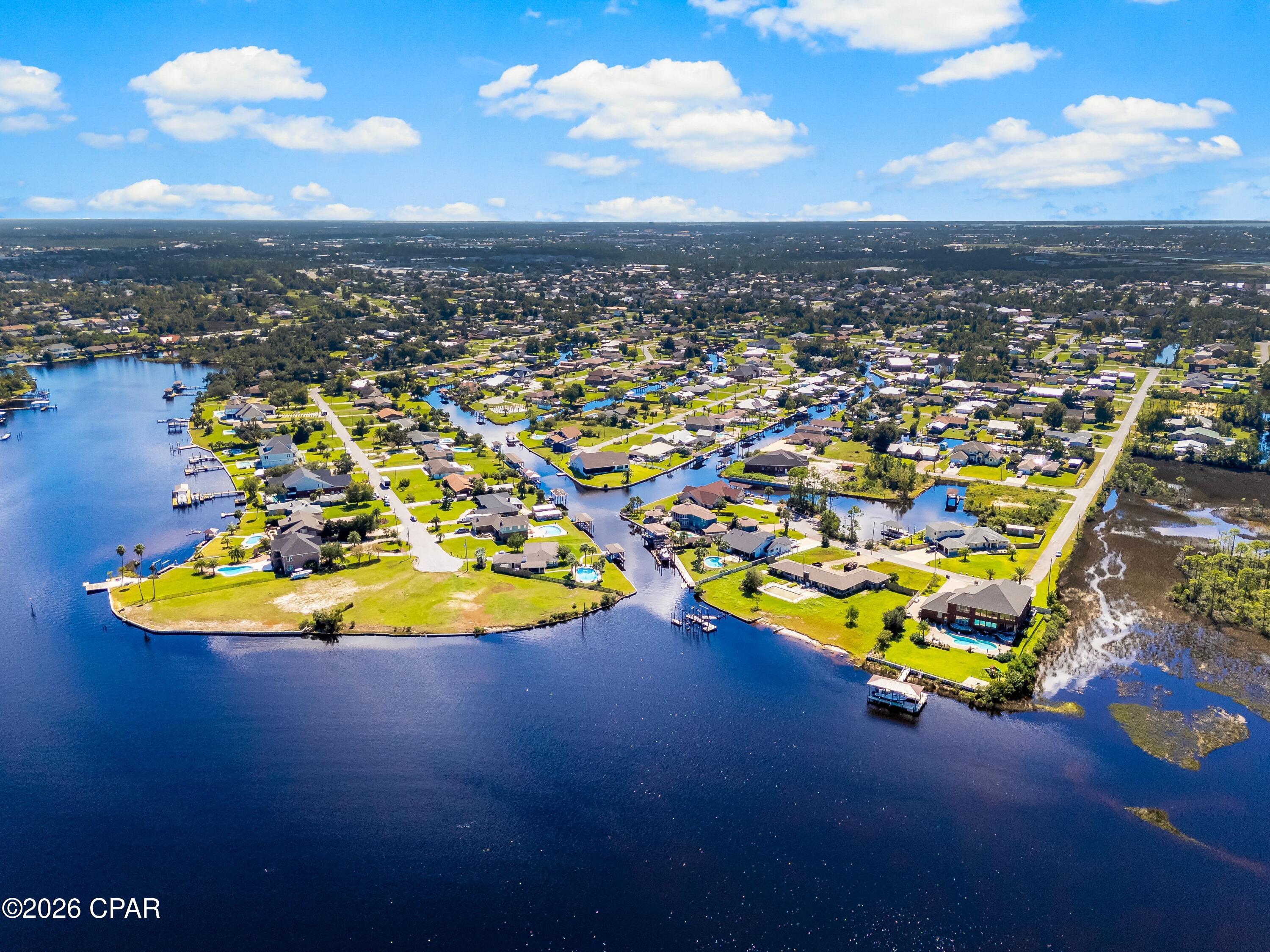 Positioned along a deep-water canal on a quiet dead-end, oak-canopied street, 4439 Vista Lane offers a relaxed waterfront setting designed for both everyday comfort and life on the water. Located in the desirable Northshore area of Lynn Haven, free from HOA restrictions, this three-bedroom, two-bath residence spans approximately 2,505 square feet and offers generous interior living space with direct boating access. The home's canal frontage is a defining feature, allowing you to step outside and head straight onto the water. A seawall replaced in 2022 and boat lift motors newly installed in 2025 within a covered boathouse enhance the property's functionality, making it easy to launch a boat and spend the day exploring the surrounding waterways, cruising toward Shell Island, or venturing out into the Gulf. The peaceful canal setting also creates an inviting backdrop for outdoor relaxation, whether enjoying morning coffee by the water or unwinding in the evening with a coastal breeze. A fully fenced backyard adds both privacy and practicality, ideal for pets, gatherings, or simply enjoying the outdoor space. Inside, the residence offers a spacious layout with flexible living areas suited for both quiet evenings and lively gatherings. Multiple living spaces allow for comfortable day-to-day living while providing room to entertain family and friends. Large windows invite natural light throughout the interior, reinforcing the home's open and airy atmosphere. Several major system improvements add long-term confidence for the next owner. The roof and windows were replaced in 2019, while essential infrastructure, including the septic tank, drain field, lift station, and well, was updated in 2016. These thoughtful updates enhance the home's functionality and durability while supporting a low-maintenance waterfront lifestyle. The property's location further enhances its appeal. Set within the established Northshore area of Lynn Haven, the home enjoys a sense of privacy while remaining close to everyday conveniences, top-ranking schools, local dining, and shopping. Lynn Haven itself is one of the most sought-after residential communities in Bay County, valued for its strong sense of community, parks, and access to the water. From this location, residents are just a short drive from the white sand beaches of Panama City Beach while still enjoying the quieter pace of a residential coastal town. With nearby marinas, boat ramps, restaurants, and retail centers, the area offers an ideal balance between waterfront recreation and everyday convenience.