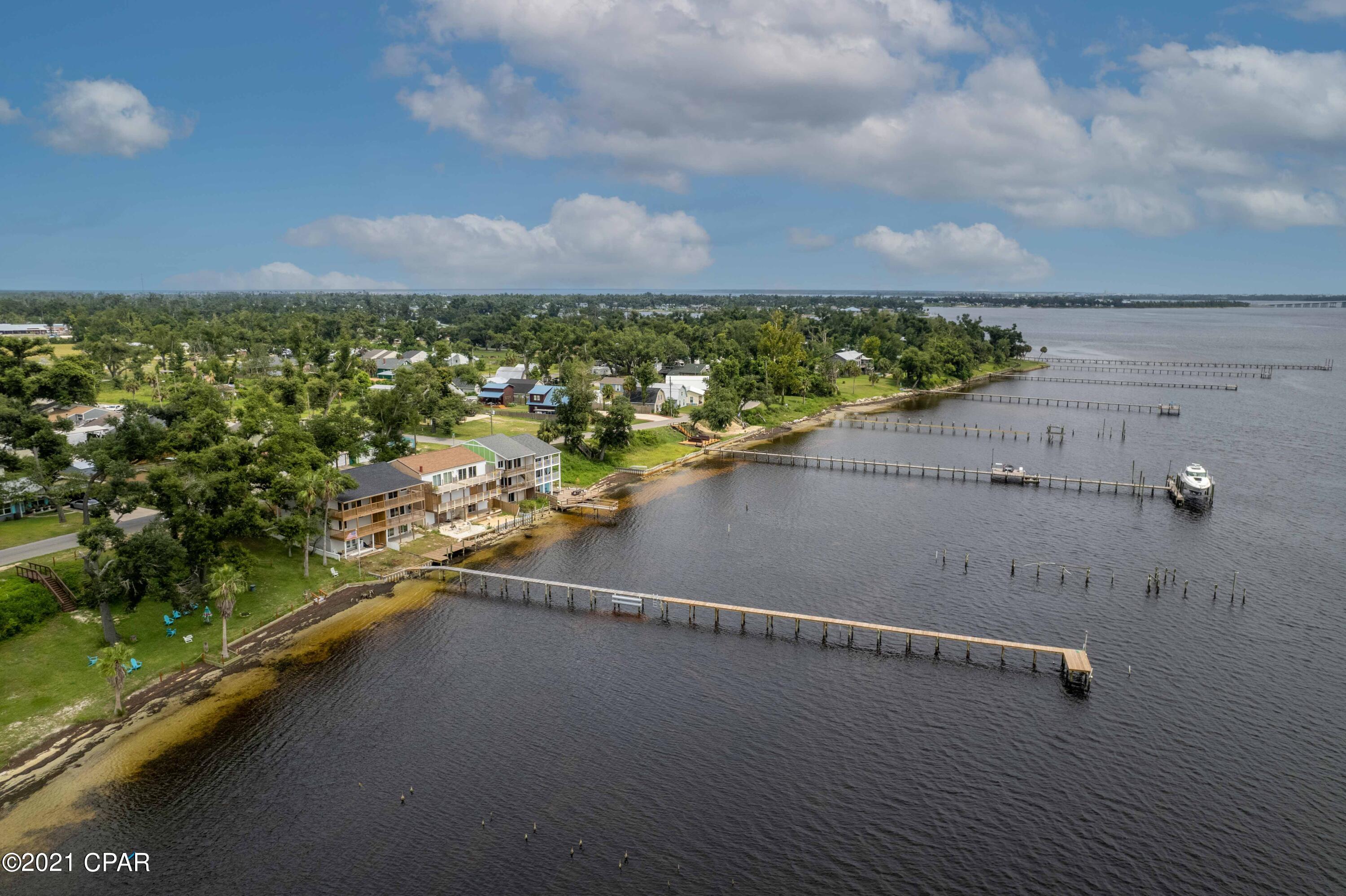 New price! Motivated seller. Beautiful waterfront home w/ amazing views of St Andrew Bay! Fully renovated 5 bed 3.5 bath, like new construction! Enter on the living level adorned w/ soaring ceilings atop open kitchen, dining area, half bath, and large living area great for entertaining. The second level includes the master suite w/ water view open to large covered balcony, 2 additional beds, and 2 baths. The bottom floor has 2 beds, a bath, laundry area, and huge recreation room w/ wet bar and patio leading to the backyard/dock. Perfect for taking the boat Bay to Gulf! Features include quartz countertops, stainless steel appliances, LVP floors, tile in baths, spectacular lighting, & custom cabinets.  Concrete driveway across the street, perfect for carport or garage.