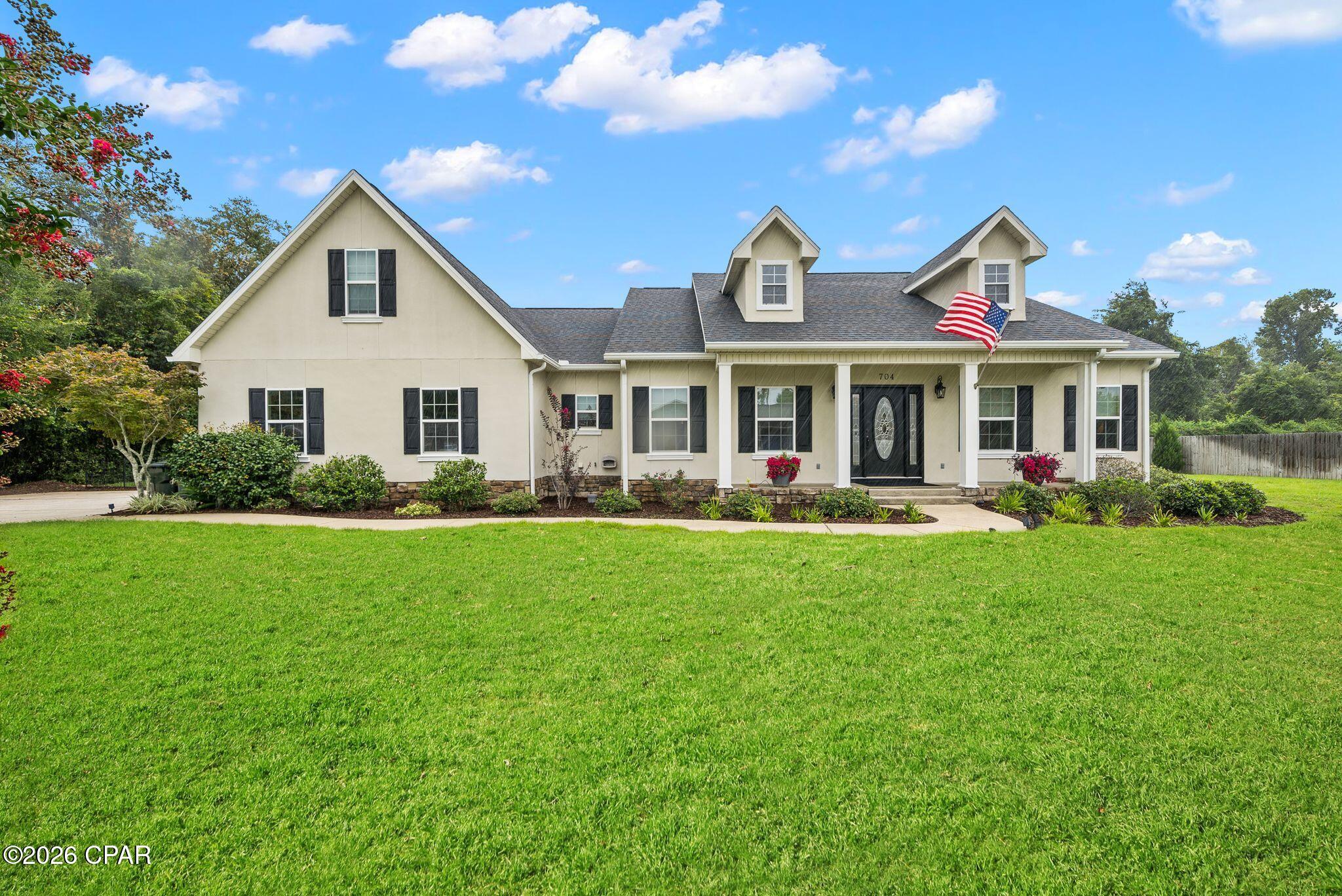 CURRENTLY UNDER CONTRACT, SELLER WILL CONSIDER BACKUP OFFERS. Prepare to fall completely in love with this captivating Lynn Haven sanctuary, radiating timeless Southern charm from the moment you pull up to its striking facade, complete with classic dormer windows, stately black shutters, and an inviting covered front porch. Step past the formal entry into a meticulously maintained interior defined by sophisticated craftsmanship, showcasing magnificent tray and coffered ceilings, deep crown moldings, elegant chair rails, and gorgeous engineered hardwood floors in the formal dining room. The heart of the home features a sun-drenched living area anchored by a cozy fireplace, flowing effortlessly into a kitchen equipped with custom wood cabinetry, brilliant under-counter lighting, and a suite of premium stainless steel appliances--including a newly upgraded induction stove and dishwasher. Perfect for the modern professional seeking an effortless hybrid or remote workspace, one of the bedrooms features a masterfully designed, custom built-in office with extensive cabinetry and shelving to ensure peak productivity in absolute comfort.  Designed with an intelligent, ultra-private split layout, the home ensures that the carpeted personal spaces never share a common wall, creating an incredibly peaceful environment for everyone. The primary suite is a true luxury retreat, boasting a cleverly redesigned private entrance and a spectacular spa-like bathroom complete with an expansive double vanity, a deep soaking tub wrapped in elegant floor-to-ceiling tile, and a seamless glass shower. On the opposite side of the home, a generous guest wing offers standalone comfort with its own double-sink vanity and private bath, while a versatile upstairs bonus room features a custom-built closet to fit your exact lifestyle needs. The jaw-dropping crown jewel of this estate is the outdoor entertainment oasis. A massive, fully screened sunporch seamlessly expands your living space, easily hosting large gatherings of 18 to 20 guests for unforgettable indoor-outdoor dining while looking out over a pristine pool deck finished in premium pavers, a stunning custom gazebo, and a fully fenced yard serviced by an automated front and side yard sprinkler system. The property owner behind keeps a beautiful wooded backdrop that makes you feel your living in the country.  With a new roof installed in 2019 providing ultimate peace of mind, this turnkey paradise perfectly balances quiet luxury with peak everyday functionality. *The grass in some exterior photos has been digitally touched up. Due to the seller being away for 9 months, a broken sprinkler head was missed causing a few patches of dry grass over time. The grass has been reseeded, is being watered and is making its way back.