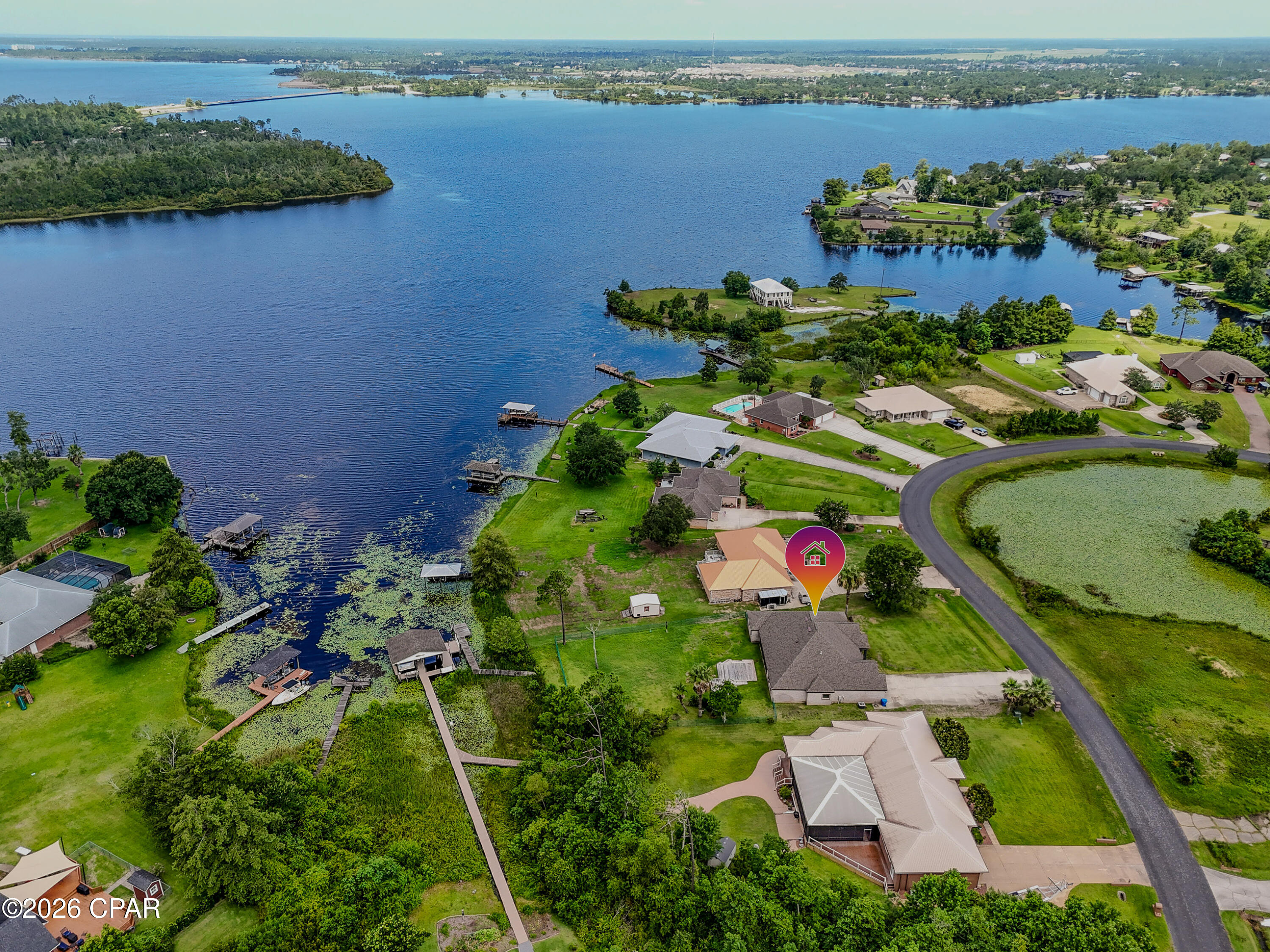 Welcome to your custom waterfront retreat on the shores of Deer Point Lake, where comfort, style, and stunning views come together with no HOA.

This beautifully designed 4 bedroom, 3 bath home offers the perfect blend of luxury and functionality. From the moment you step inside, you are greeted by soaring beamed ceilings in the living room, creating a warm yet impressive gathering space filled with natural light.

Just off the entry, a spacious home office sits behind a custom barn door, ideal for remote work or a quiet flex space. Across the hall, the formal dining room showcases a striking wood ceiling and detailed molding, adding charm and character.

The heart of the home is the open concept kitchen, featuring a custom copper farmhouse sink, modern cabinetry, stone backsplash, and a large breakfast bar perfect for family and entertaining. Flowing seamlessly into the living area, you will find built in bookshelves, an electric fireplace, and beautiful views of the oversized screened porch and lake beyond.

Designed with a split floor plan, one side of the home offers three oversized bedrooms and two full baths, providing comfort and privacy for family or guests. On the opposite side, the spacious primary suite serves as a true retreat, complete with room for a sitting area, a spa like bathroom with dual shower heads, soaking tub, walk in closet, and private patio access with breathtaking lake views.

Outside is where this home truly shines. Relax on the large screened porch, sip your morning coffee overlooking the water, or head down to the brand new dock for easy access to everything Deer Point Lake has to offer.

Thoughtfully designed inside and out, this exceptional lakefront home offers peaceful waterfront living in Panama City with space to grow, entertain, and make lifelong memories.