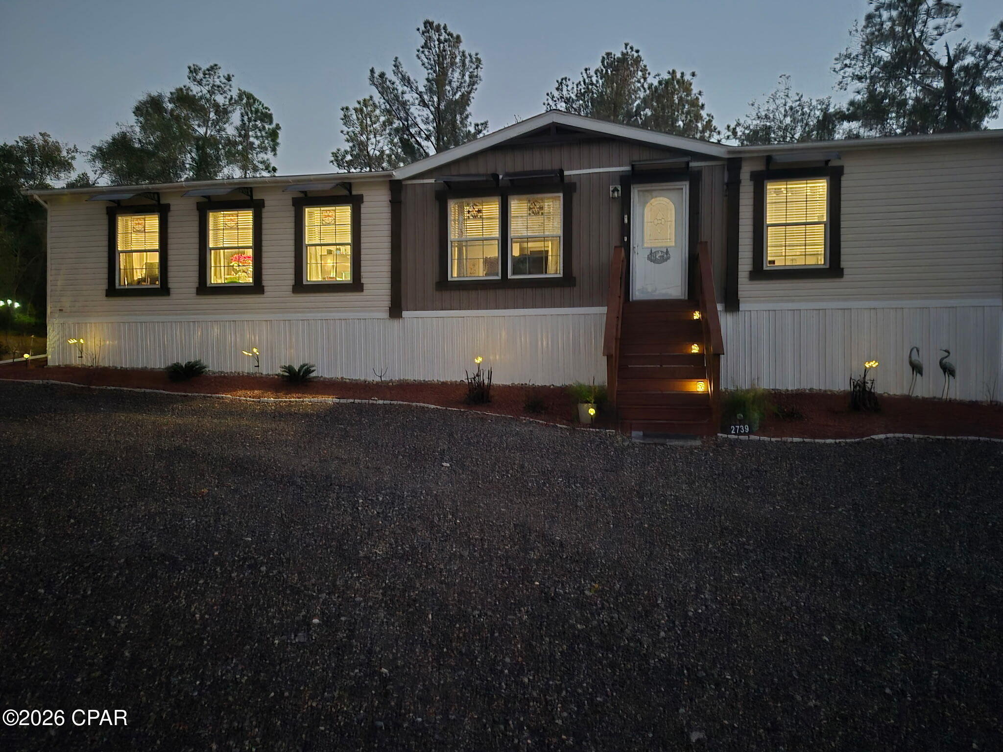 Owners are MOTIVATED, they are having to move for health reasons.  Located in the Compass Lake in the Hills resort community.  Go to their website to check out all the amenities you will have access to for a low $135 yearly. 2024 manufactured home in like-new condition (completed less than one year ago) offers a rare blend of new construction and fully developed outdoor living on 2.02 high-and-dry acres tucked away on a quiet cul-de-sac.
The thoughtfully designed 1,780-square-foot, 3-bedroom, 2-bath home features a spacious open layout with a large kitchen and center island, generous living area. IN addition to the kitchen appliances the washer and dryer will convey with purchase.  In addition to the standard smoke detectors.  Photo electric smoke detectors have been installed.  Filtration systems have been installed underneath all sinks.   Seamless flow to the outdoors--ideal for both everyday living and entertaining. The home is serviced by a private well drawing from Florida's natural aquifer system, providing a reliable, independent water supply. For added peace of mind, the property is equipped with perimeter security cameras, motion sensors, and wildlife/game cameras, offering enhanced safety and situational awareness throughout the grounds. Outside, the property truly shines as a private retreat-style compound. A fully equipped outdoor kitchen under a 12×12 metal pavilion includes stainless steel prep tables, grill, griddle, four-burner stove, gas pizza oven, and stainless sink--designed for serious outdoor cooking and year-round gatherings. Multiple outdoor living zones include a hot tub area surrounded by native palmetto and smokeless fire pit areas, creating comfortable, low-smoke spaces for relaxation and entertaining.
Nature lovers will appreciate the walking and nature trails winding through the wooded acreage, along with established centipede sod, mature pine, and native landscaping. The grounds also feature established fruit trees including banana, fig, pomegranate, and orange, plus an 8×12 greenhouse and a large fenced garden with 24 blueberry bushes, offering a productive and well-planned growing space. Two 12×14 metal storage sheds.  Two 24×20 covered carports and a covered 10×10 outdoor dog kennel. A level, fenced recreational area is currently configured for low-impact .22 caliber and air rifle use with four shooting tables and lanes, and can easily be repurposed into a corral or paddock for mini horses or other animals. This property offers the peace of mind of a newer home combined with the luxury of fully finished land, extensive outdoor amenities, flexible spaces, modern security features, and independent utilities--elements rarely found together at this price point--making it ideal for full-time living, a second home, or a private Florida retreat.  If under contract in the first 30 days the following items shall convey with purchase: Some photos were provided by the seller.