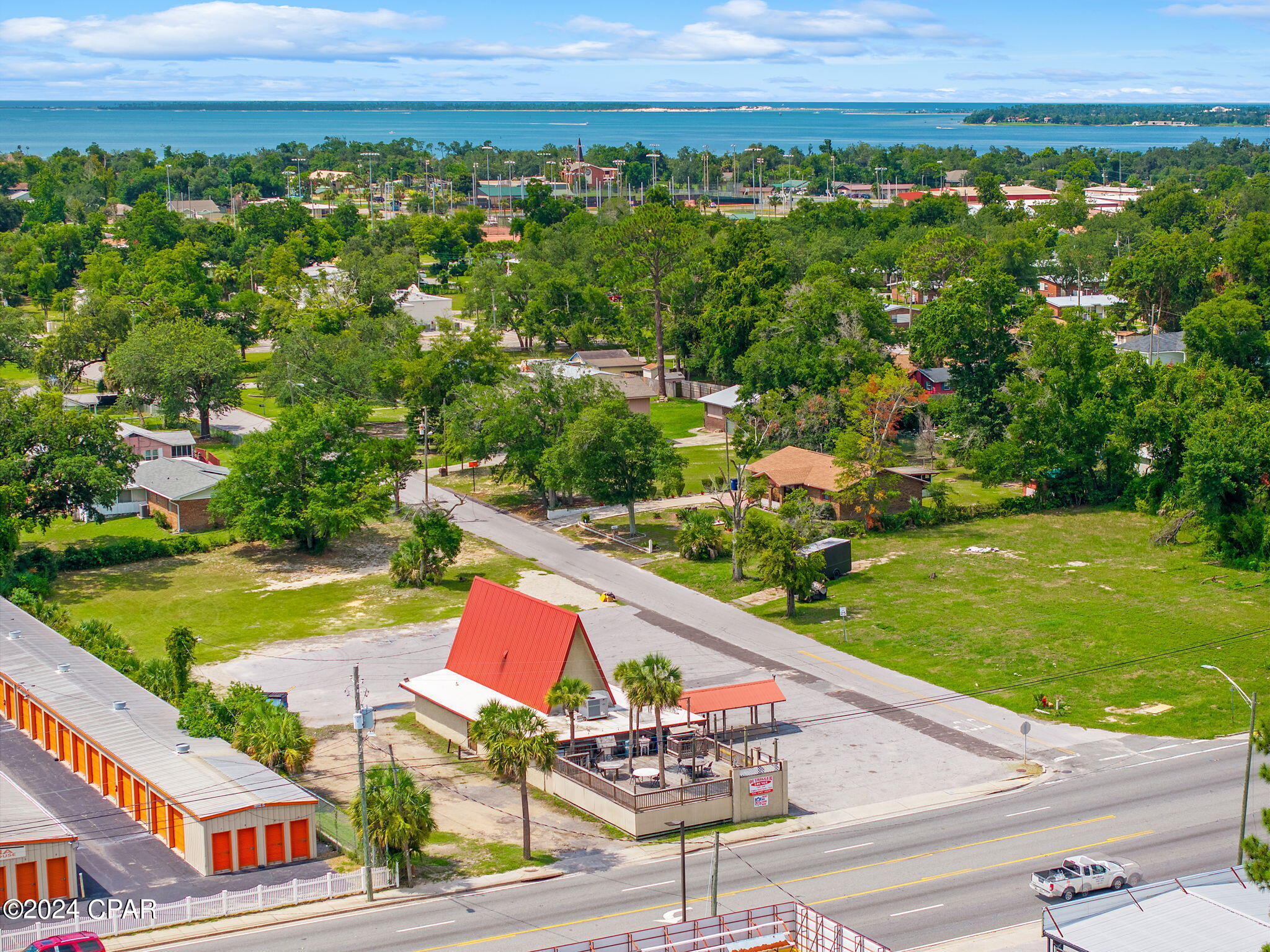 Seize the opportunity to own a premier commercial property situated on a high-traffic corner lot along the bustling Highway 98 in Panama City. With 125 feet of prime frontage and a substantial property depth of 300 feet, this CG-2 zoned lot is located in one of the highest volume traffic count areas, boasting an average daily traffic count of close to 40,000. The site covers a little under 1 acre and offers unparalleled visibility and accessibility for any business. The property features a well-appointed lounge interior with a stunning 30-foot solid wood bar that is stained, sealed, and fully equipped with all necessary amenities. The exterior deck area, spanning 1,184 square feet, offers a versatile space for outdoor events or dining. 

This property also boasts modern infrastructure with significant recent upgrades: the roof was replaced in 2018, one air conditioning unit was replaced in 2021, and the other in 2023. Additionally, the main waterline and sewer line to and from the building were replaced in 2022. This could be an unbelievable redevelopment site, as the majority of the property is cleared. Perfect for retail, office, or service-oriented businesses seeking a high-profile location with substantial amenities, this is a prime opportunity to enhance your business presence in a thriving commercial area.