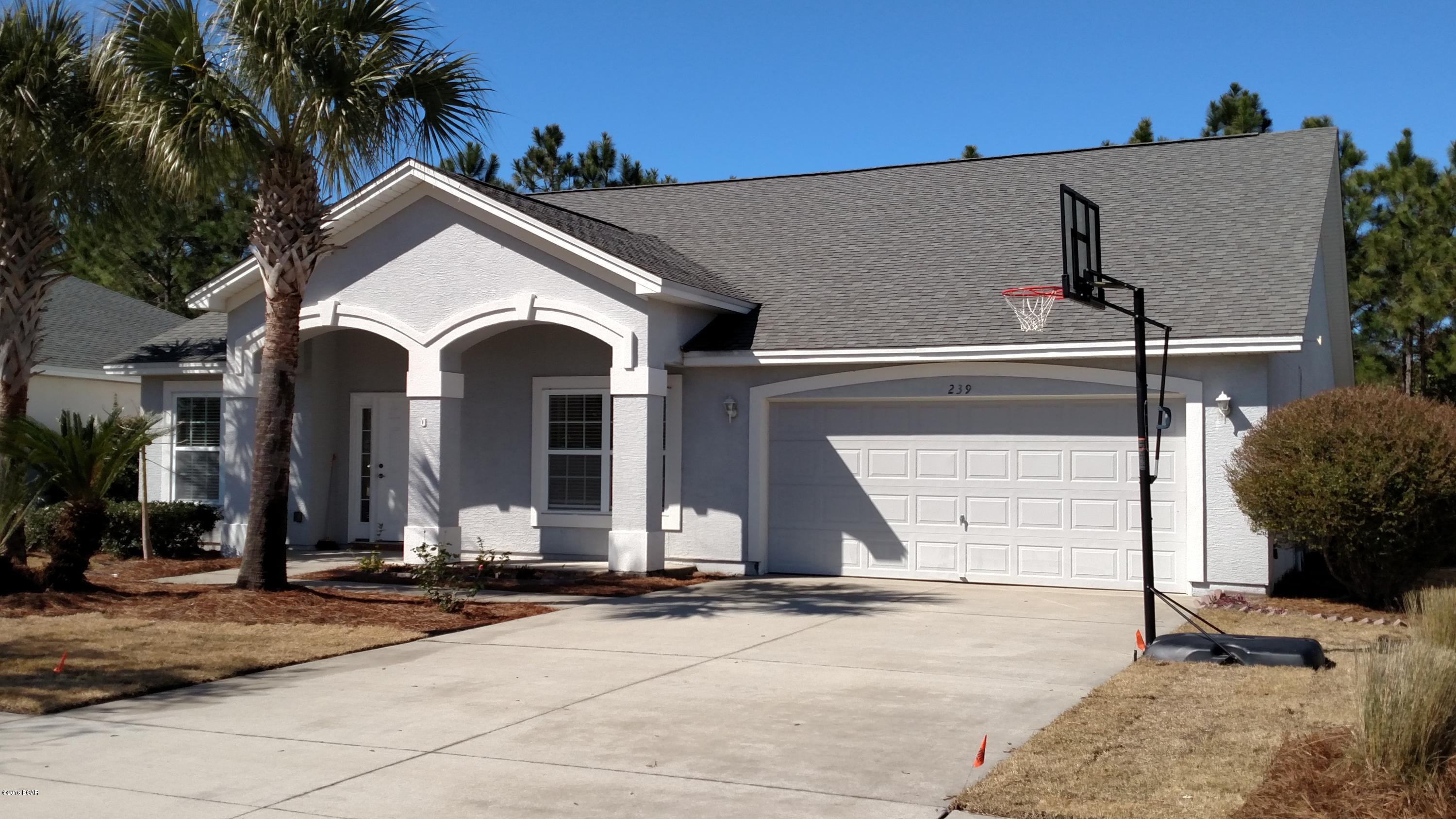 Spacious and inviting, this 4 bedroom 2.5 bath sits quietly in Palmetto Trace. Easy walk to one of the subdivision's tow community pools. Close to Pier Park and to the Beach, golf carts are welcome.  Split bedroom contemporary features lofted ceilings in the main living areas which include formal living and dining rooms as well as large family room. The kitchen has it's own eat-in area and is completely tiled with custom cabinets and Corian countertops. Master suite features his and her walk-in closets as well as dual vanities with cultured marble. Attached 2 car garage and enclosed back patio complete the package. Dogs are allowed with approval and non-refundable pet fee.