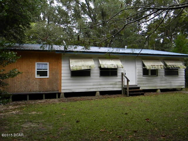 Bring your tools and imagination to finish this  home in the country on a nice acre lot convenient to Panama City and Chipley with 2 nice sized bedrooms, open living/dining area, metal roof and an addition that could be a computer or additional bedroom.  Call to see today.