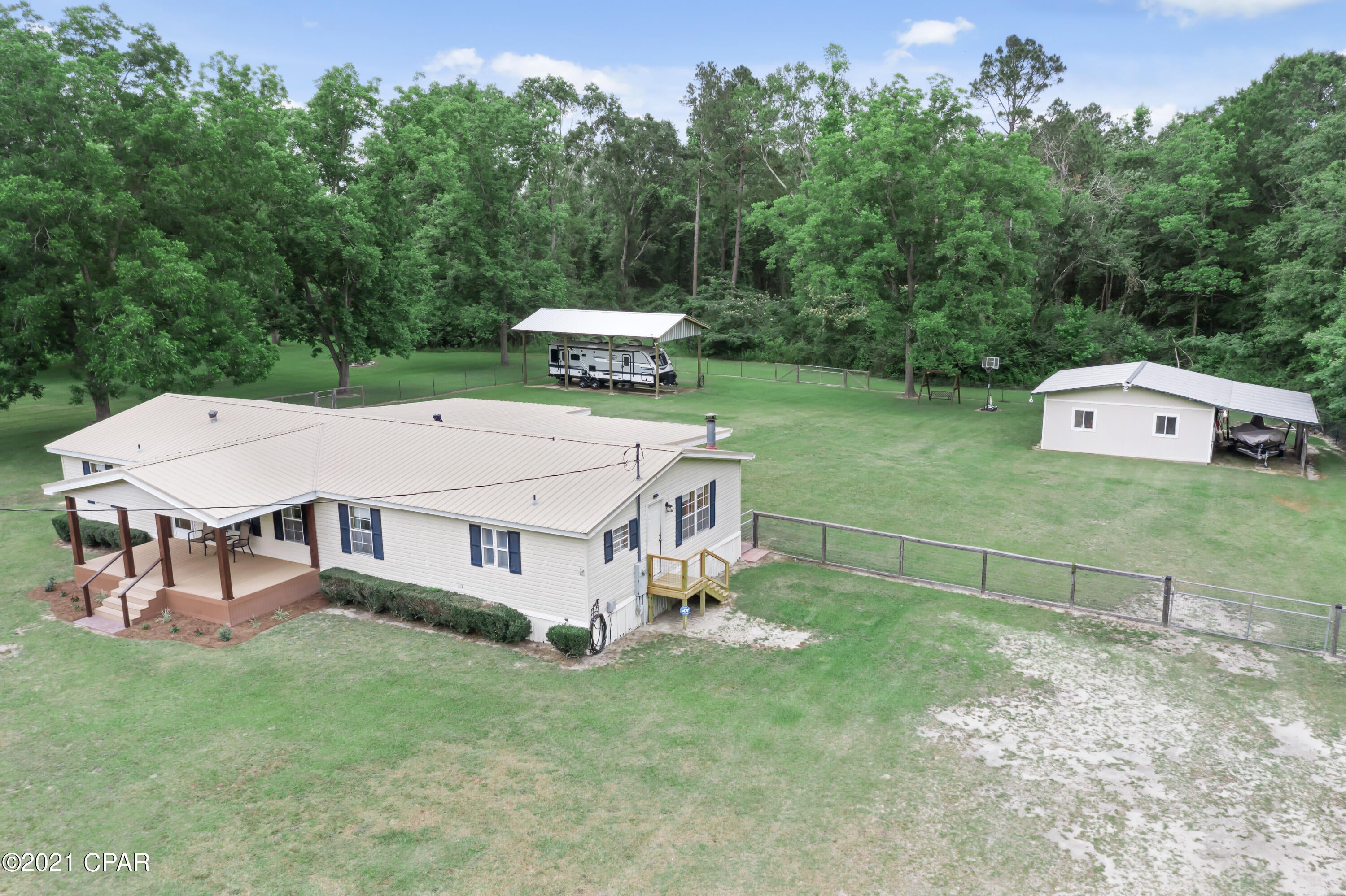 Well Maintained....Four Bedroom, Two Bath Mobile home sitting on over 4 acres. Home features formal living, den with wood burning fireplace. Master bedroom with his and her walk in closets, updated master bath with raised double vanities with shower unit. Kitchen is open to den area. Utility room has room for freezer.  Ac unit is just few years old...metal room. Covered front porch, 10x26 covered back porch. Covered Rv storage, Large barn both have water and electric. Backyard has chain link fenced. And so much more!