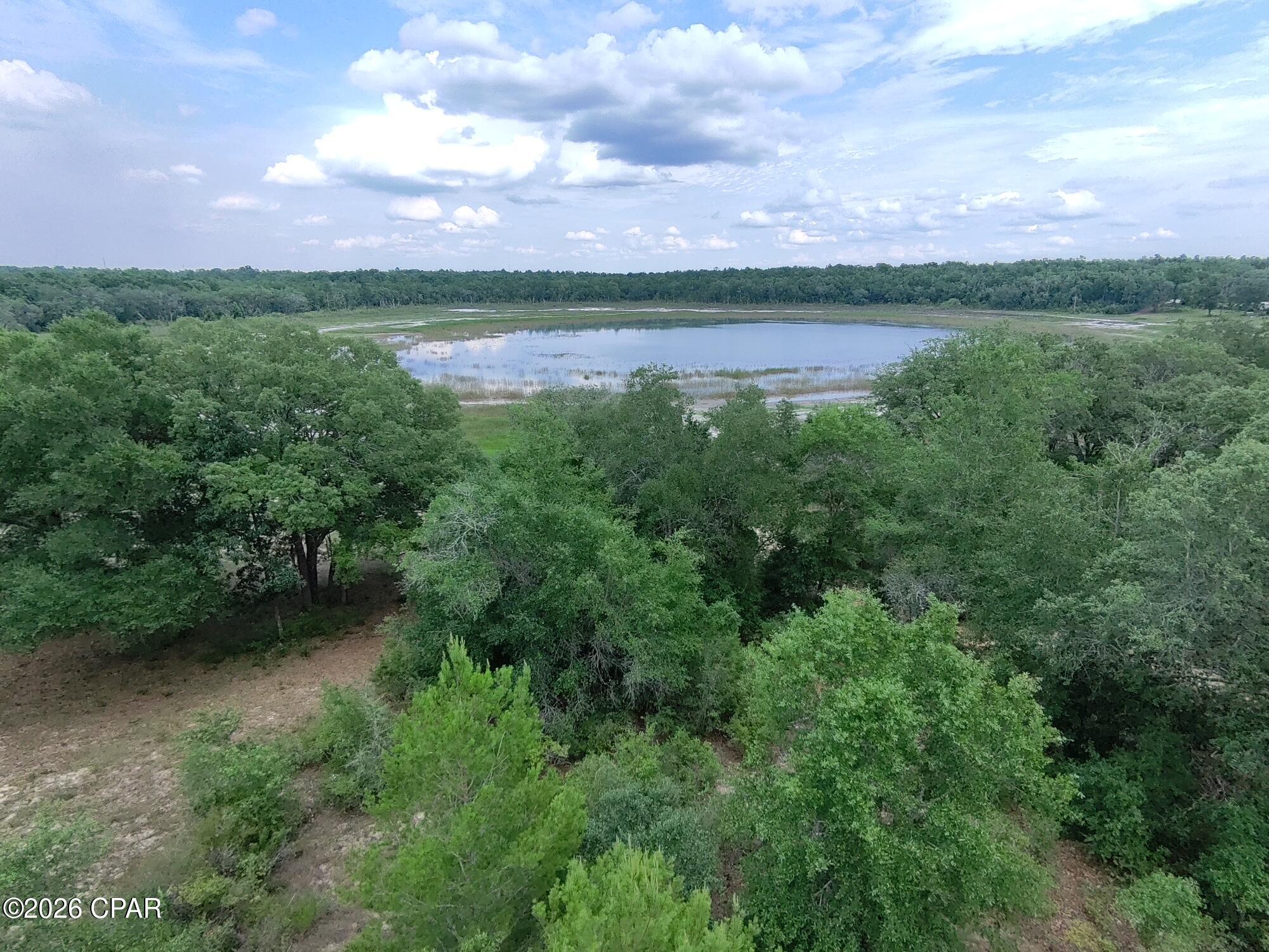 RARE WATER-VIEW OPPORTUNITY IN SUNNY HILLS!

Don't miss your chance to own one of the most unique homesites in all of Sunny Hills! Located at Lot 16 Chapel Avenue, this oversized 0.563-acre residential lot offers a truly special setting that is becoming increasingly difficult to find.

Positioned along the edge of a massive 71-acre Deltona-owned greenspace, this property enjoys beautiful views of Watering Lake from the rear of the lot. 

What makes this opportunity even more exceptional is its rarity. Only a small number of undeveloped lots remain around Watering Lake, and properties with this type of natural backdrop seldom come to market. The expansive greenspace behind the property creates an incredible sense of privacy and ensures that the scenic wooded and lake views will remain a defining feature of the homesite for years to come.

The lot itself is generously sized, offering plenty of room for a custom home, detached garage, workshop, or outdoor living area. Whether you're looking to build your dream home, secure a premium homesite for the future, or invest in one of Sunny Hills' most desirable locations, this property checks all the boxes.

Sunny Hills is known for its rolling hills, beautiful lakes, popular 18-hole golf course, parks, and abundant outdoor recreation opportunities. Conveniently located between Chipley and Panama City, residents enjoy a peaceful rural setting while remaining within easy reach of shopping, dining, employment centers, and the white-sand beaches of Florida's Gulf Coast.

Opportunities like this are few and far between. If you've been waiting for a premium homesite with privacy, greenspace, and lake views, this is the one. Secure your piece of Sunny Hills before it's gone.